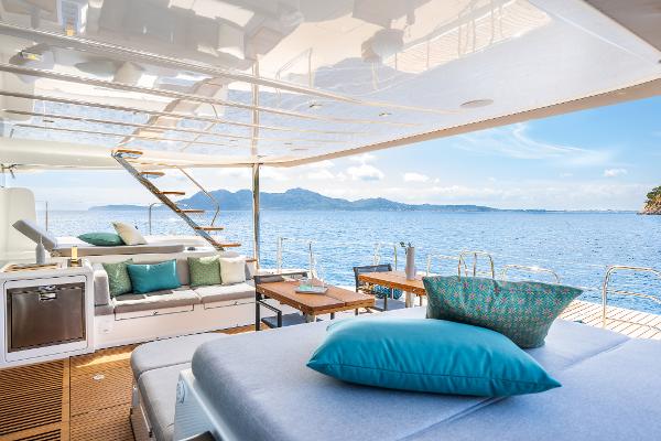 Luxurious Lagoon 60 yacht interior, 2025 model, with ocean view and elegant seating area.