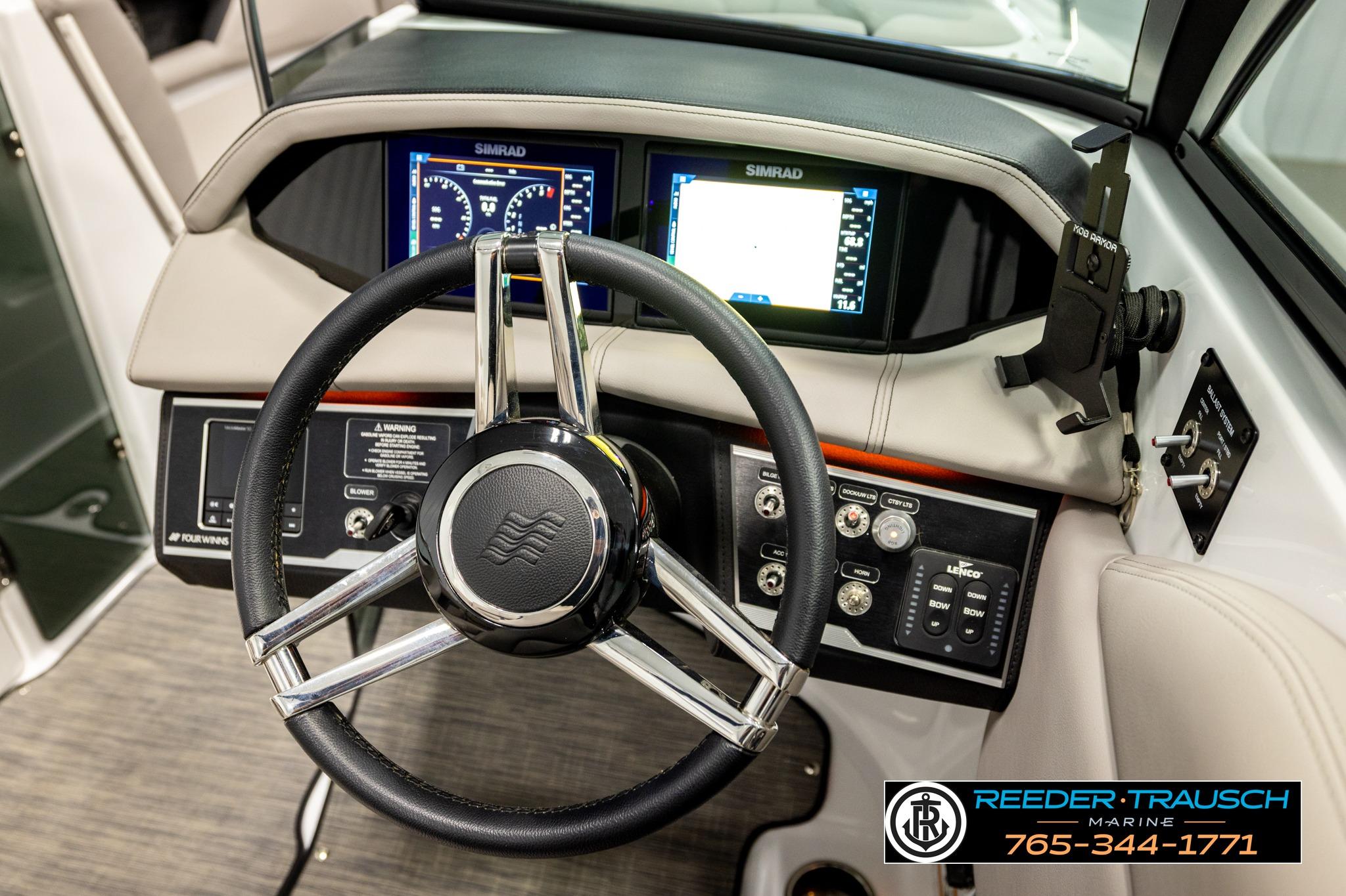 2024 FOURWINNS HD5 Surf boat dashboard with steering wheel and navigation controls.