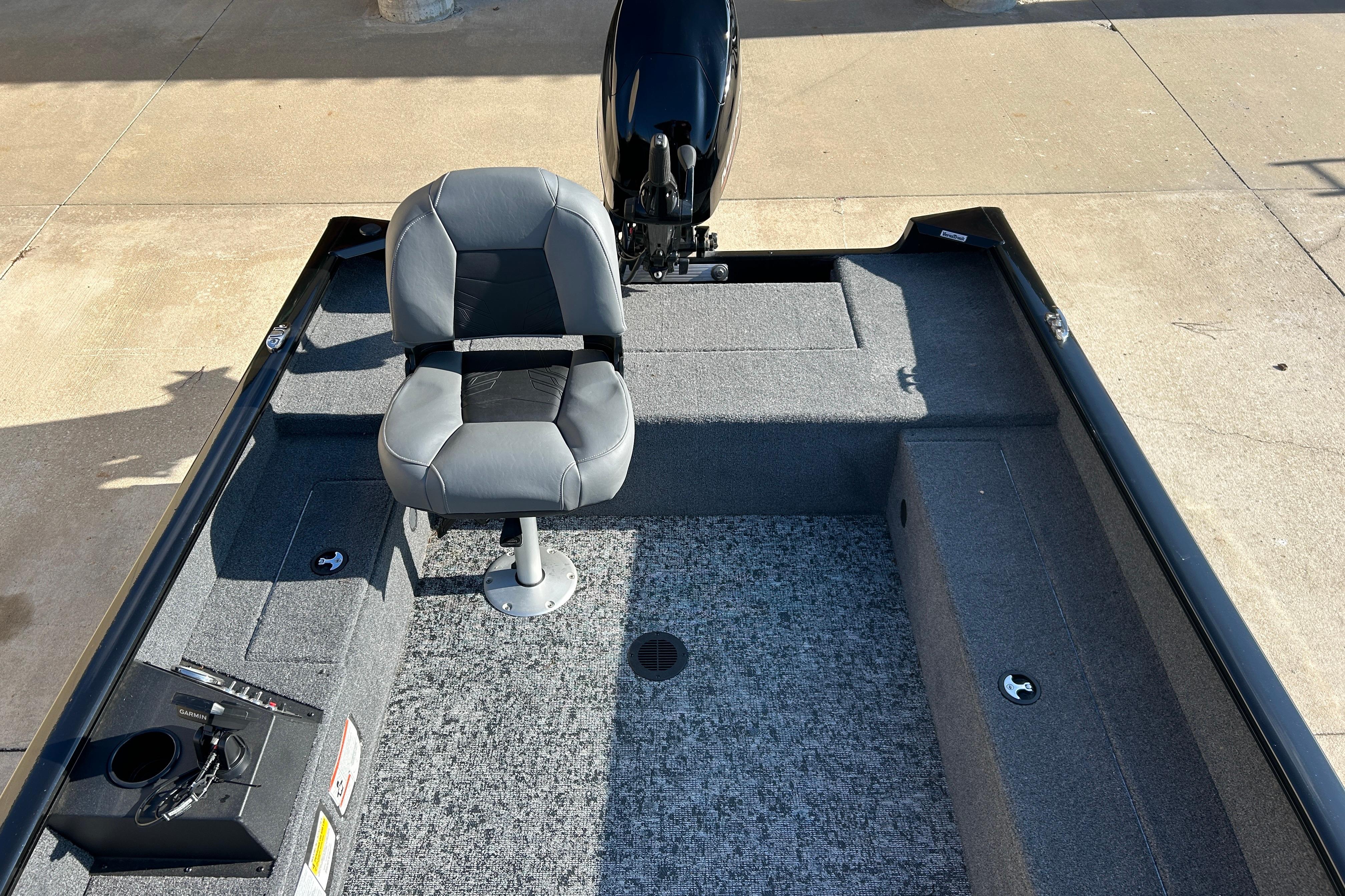 2025 Tracker Super Guide V-16 T boat interior with gray seating and motor.