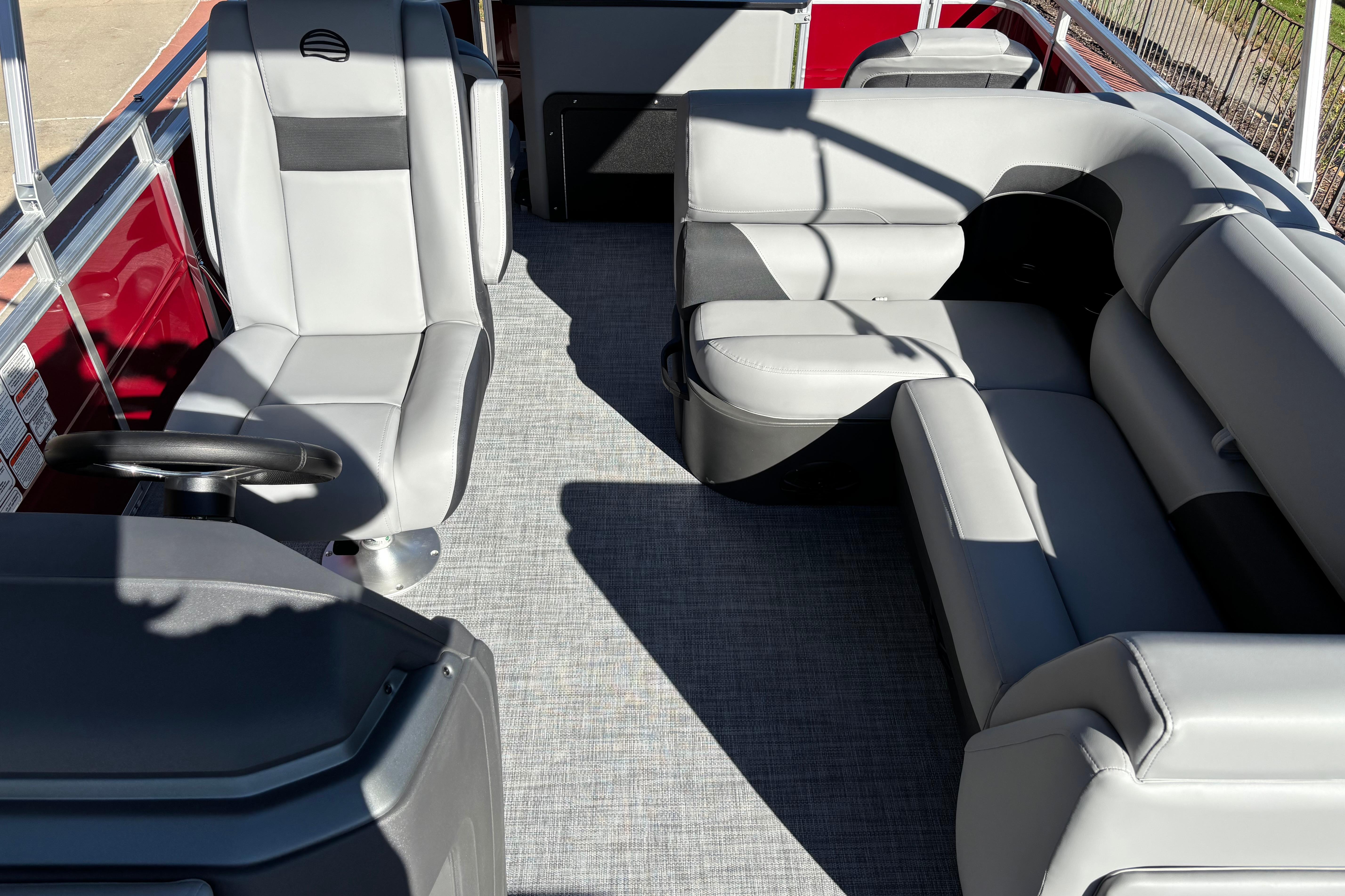 2026 Sun Tracker SportFish 20 DLX interior with gray seating and steering wheel.
