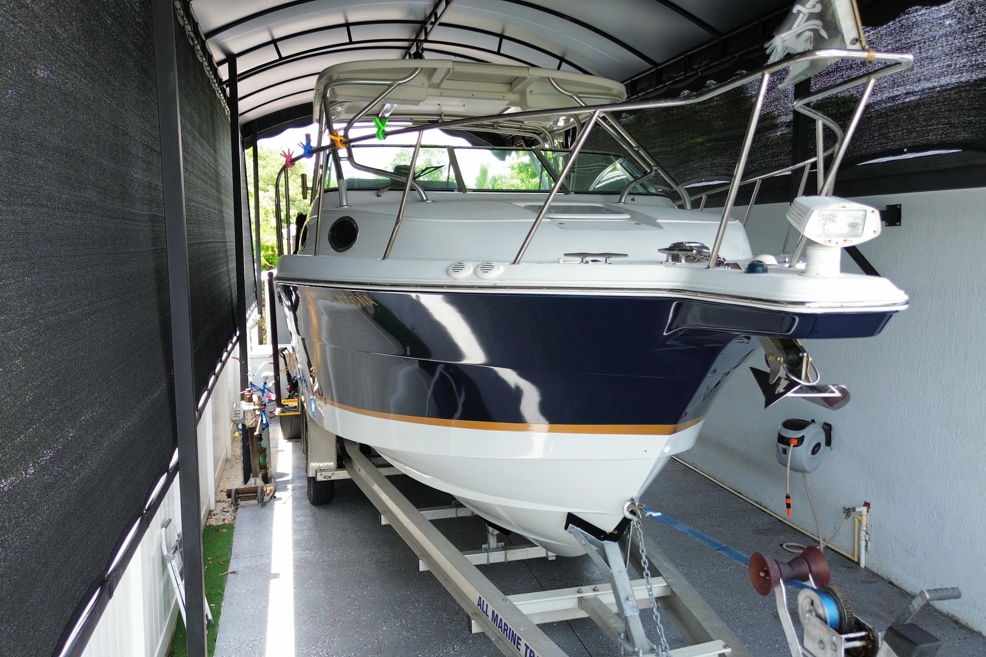 2005 Wellcraft 290 Coastal boat on trailer under a covered shelter.