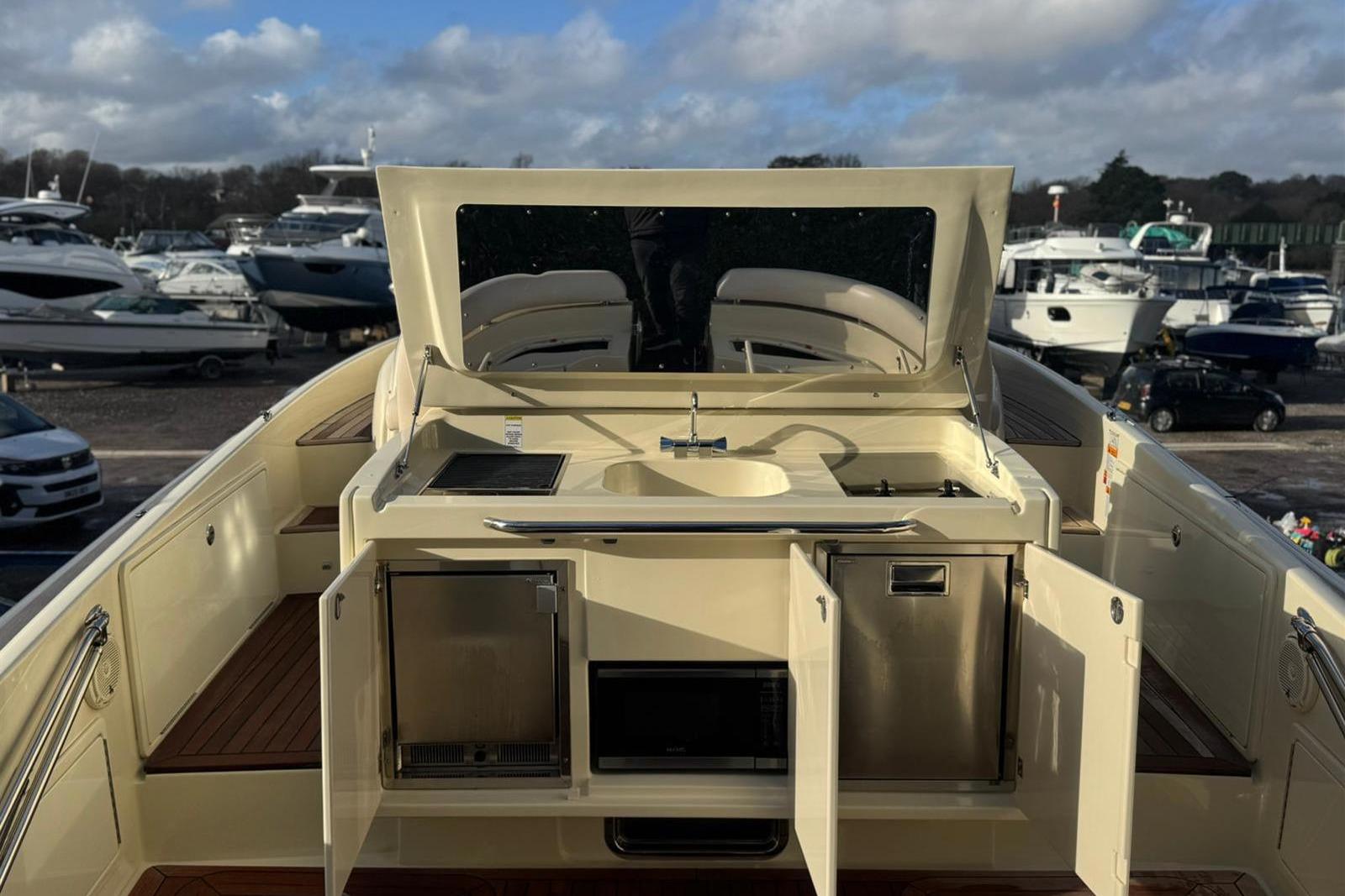 2017 Chris-Craft Launch 36 yacht with open deck kitchen and marina background.