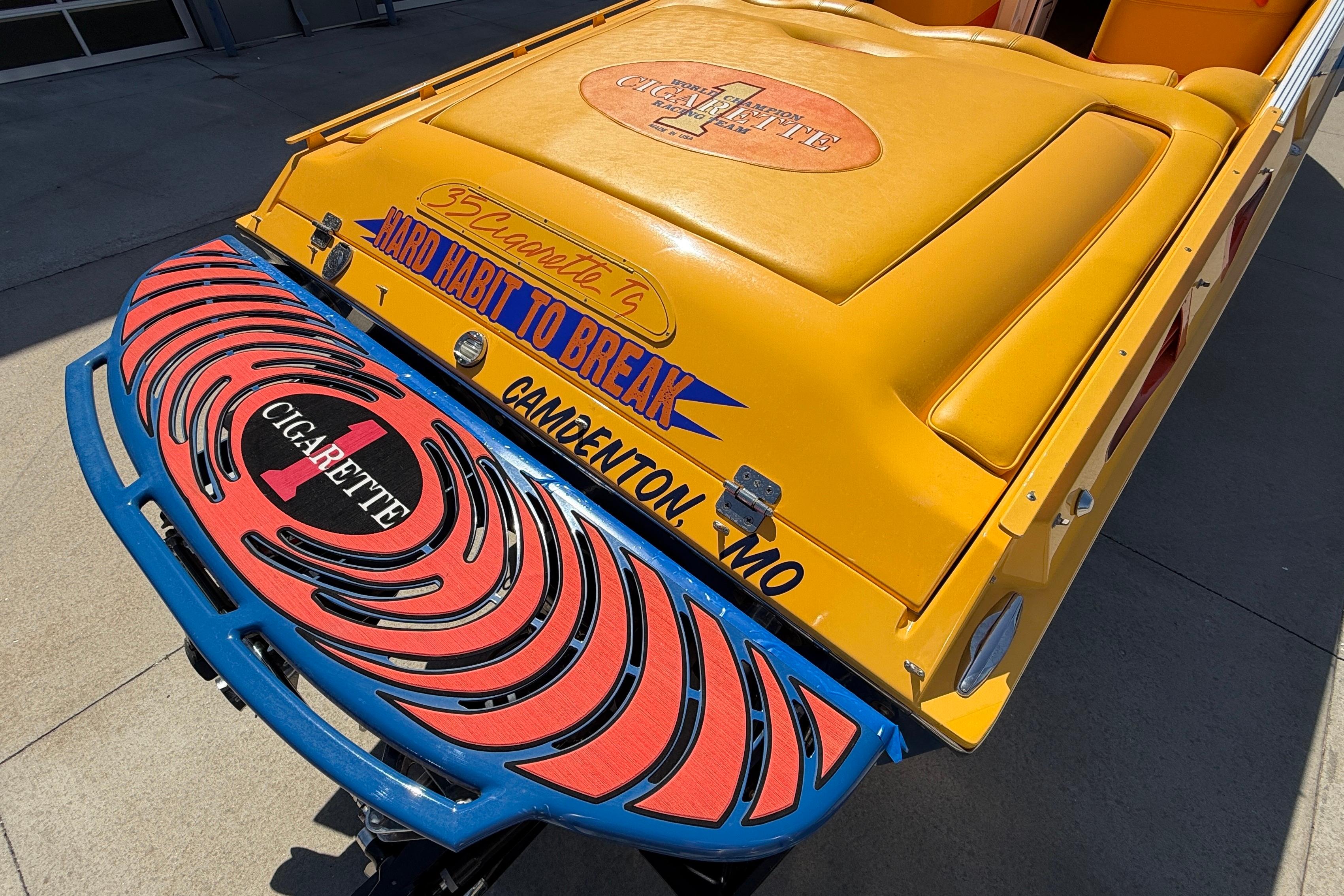 2002 Cigarette 35' Cafe Racer boat with vibrant yellow and blue design, "Hard Habit to Break."