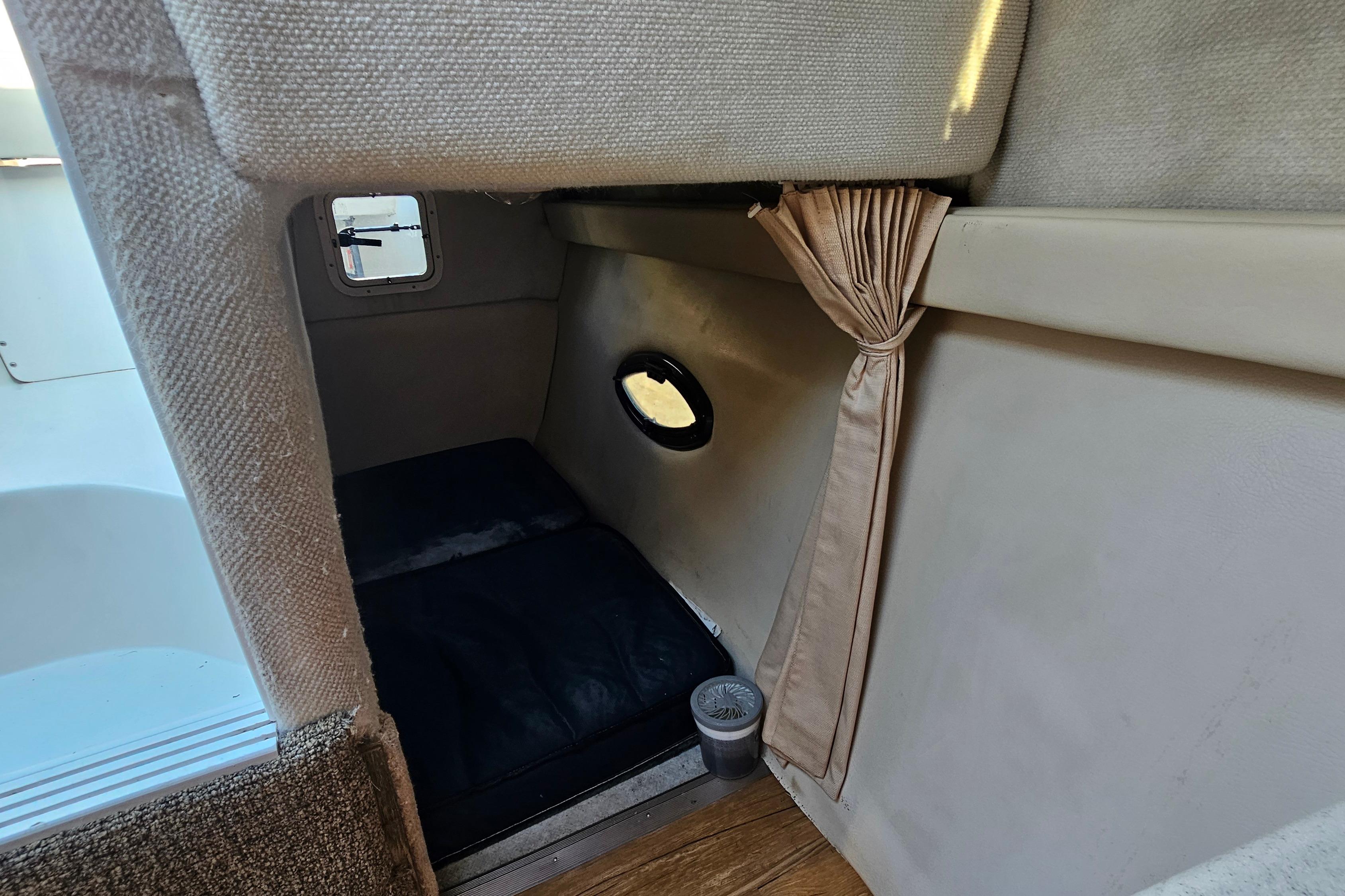 Interior cabin of 1999 Regal Commodore 258 boat with cozy sleeping area.