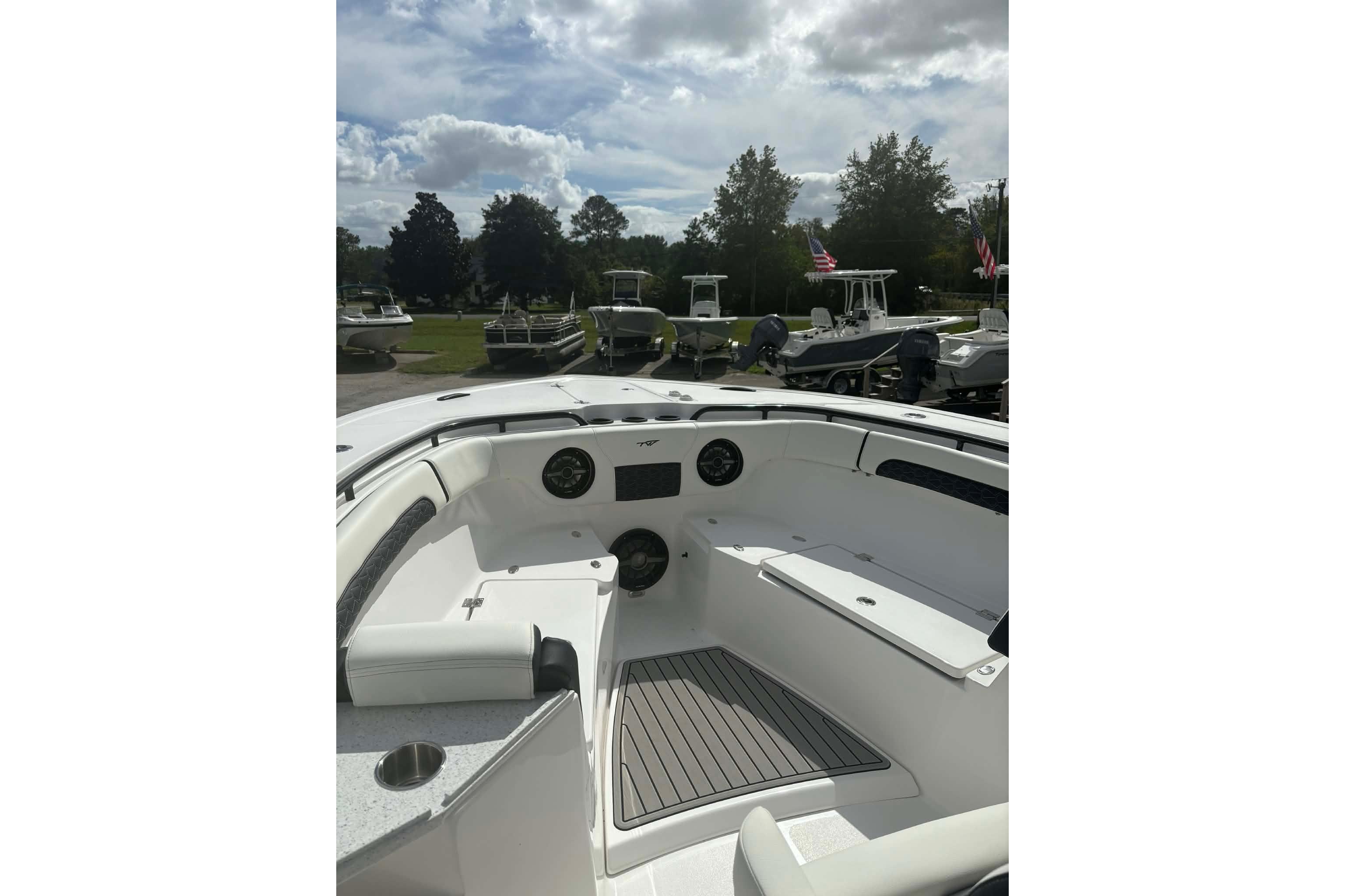2026 Tidewater 282 CC Adventure boat interior with seating and dashboard, under a cloudy sky.