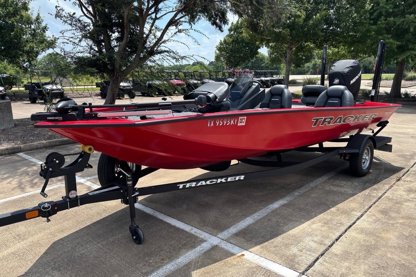 2026 Tracker Pro Team 190 TX boat in vibrant red on a trailer, parked outdoors.