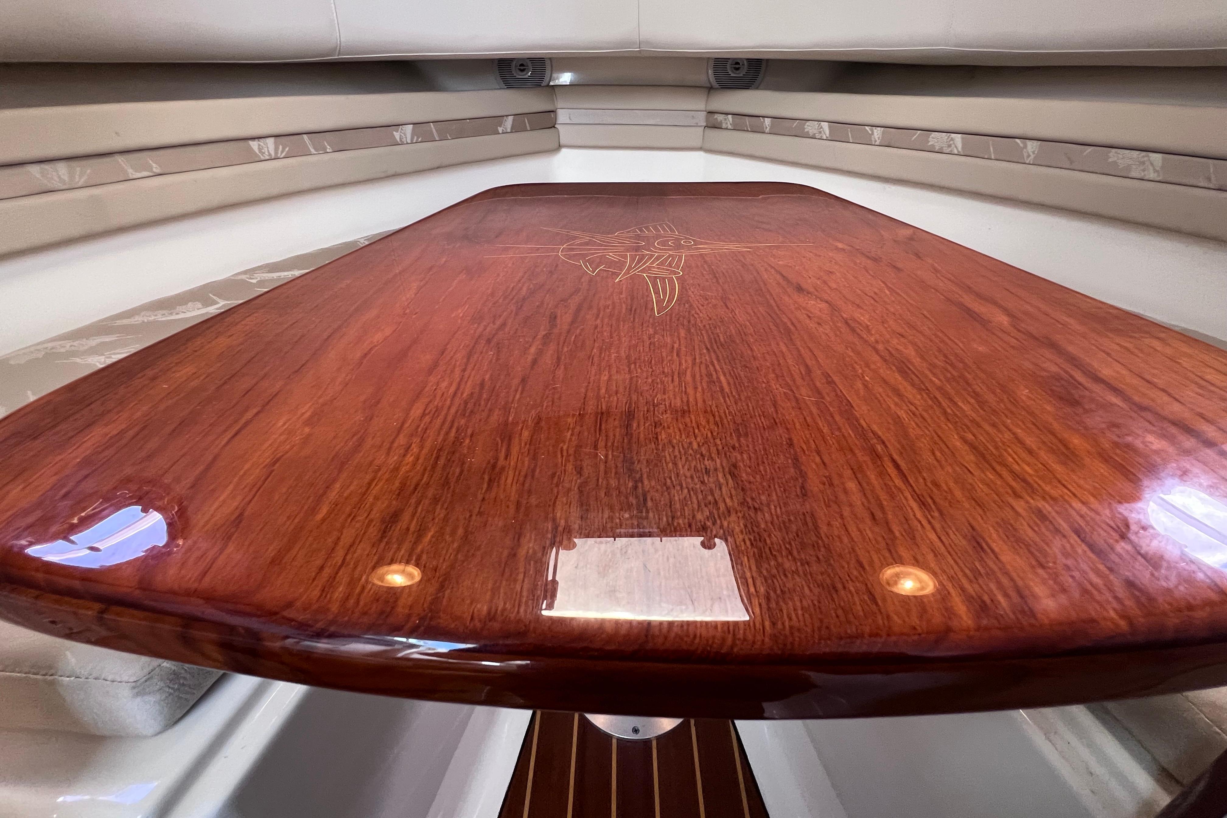 Polished wooden table inside 2004 Pursuit 2870 Walkaround boat cabin.