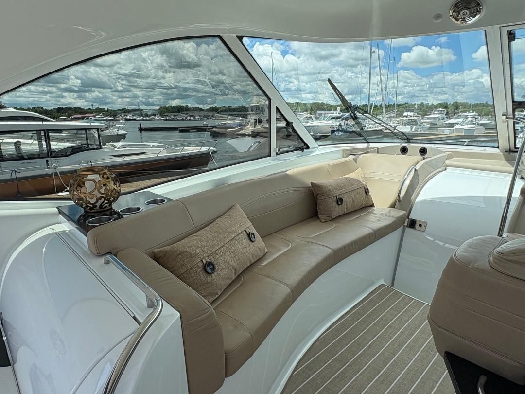 Interior of a 2011 Formula 45 with beige leather seating and panoramic windows overlooking the marina.