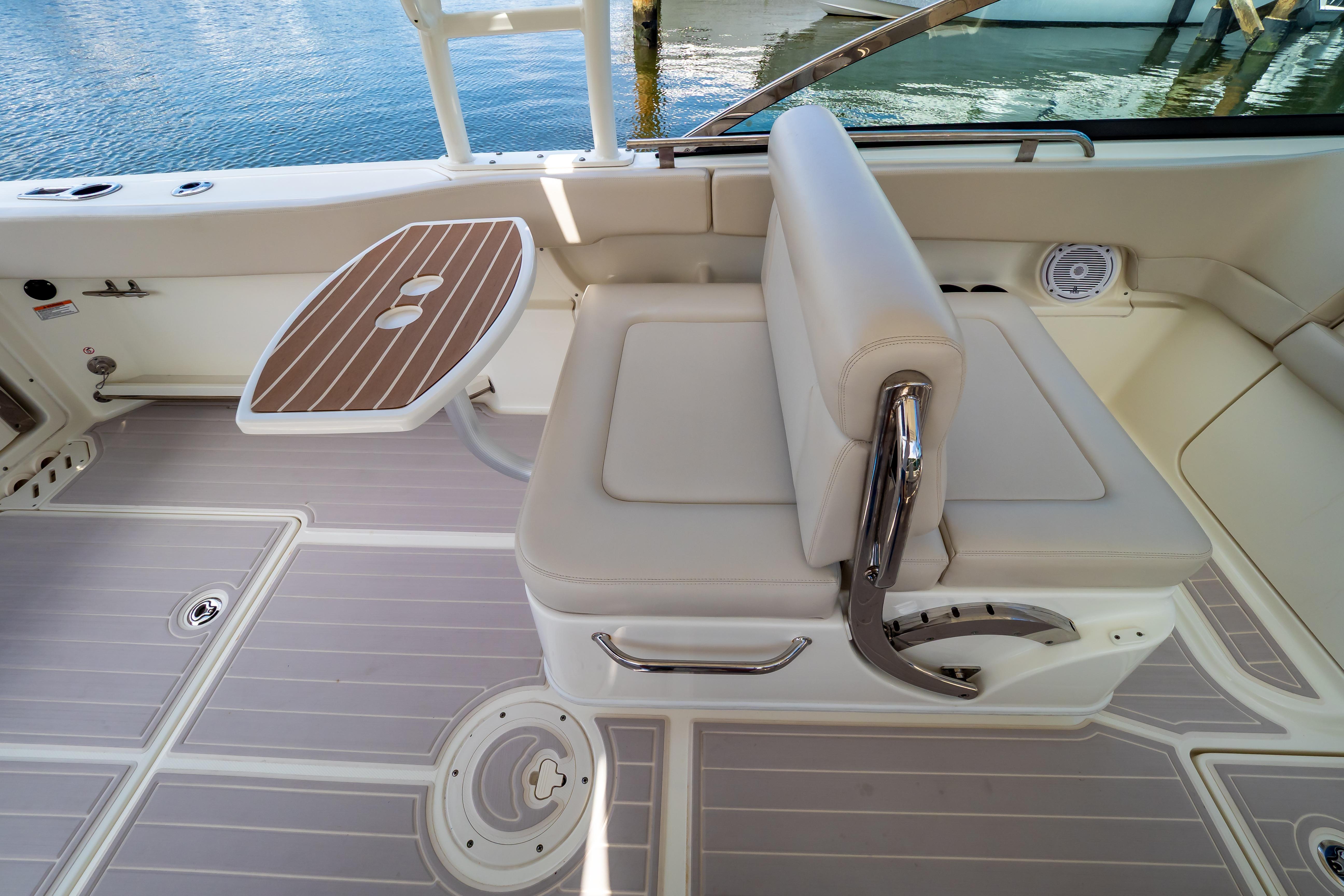 2019 Boston Whaler 270 Vantage boat interior with seating and table, docked by water.