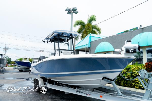 2025 Caymas 281 HB boat on trailer at dealership, featuring sleek blue design.