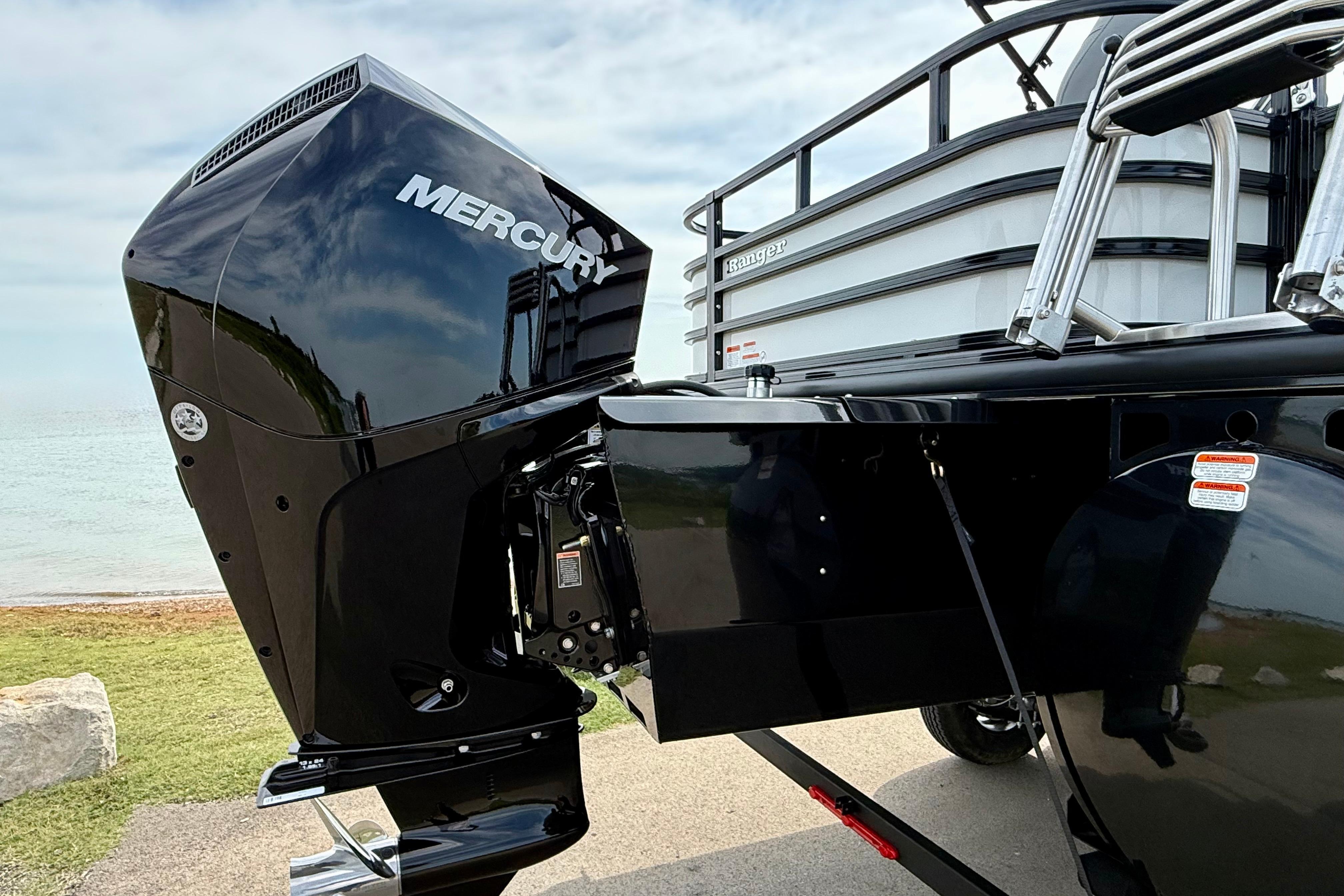 2026 Ranger 223FC boat with Mercury outboard motor by the shoreline.