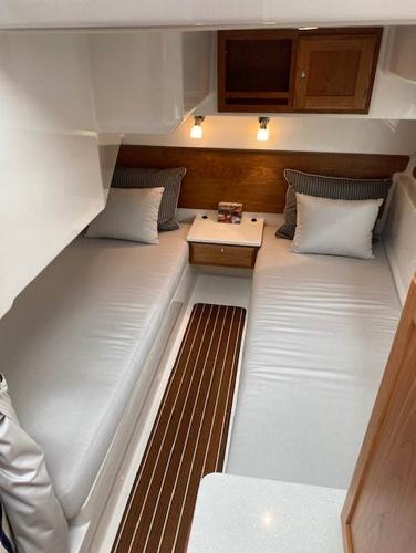 2025 Back Cove 39O cabin with twin beds, wooden accents, and modern lighting.