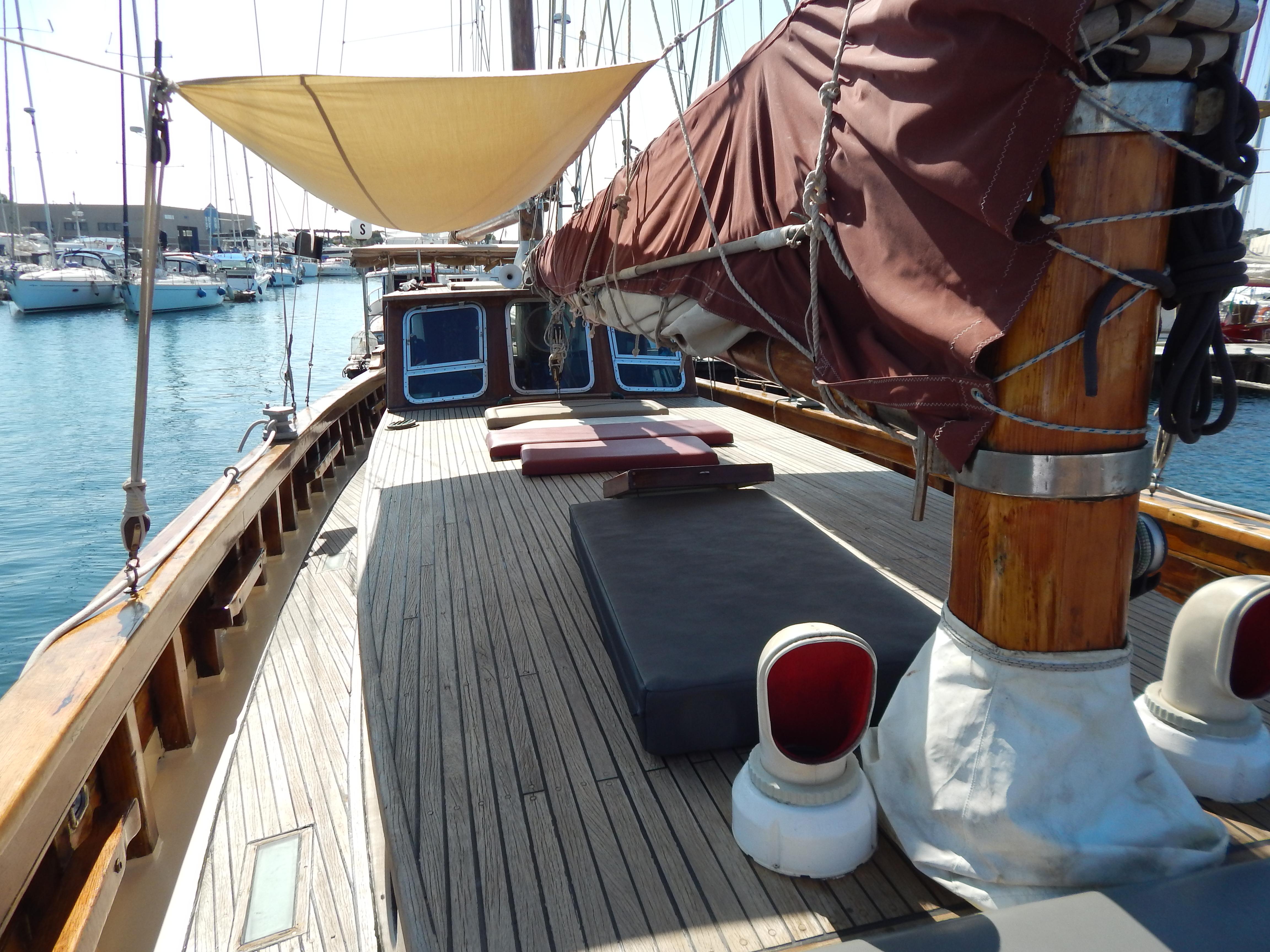 1944 Custom Schooner 22 m with wooden deck, docked at marina, featuring sails and sunshade.