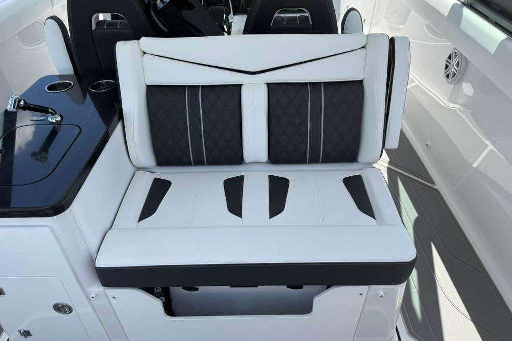 Luxury seating on 2026 Monterey Elite 30 OB boat, featuring sleek black and white design.