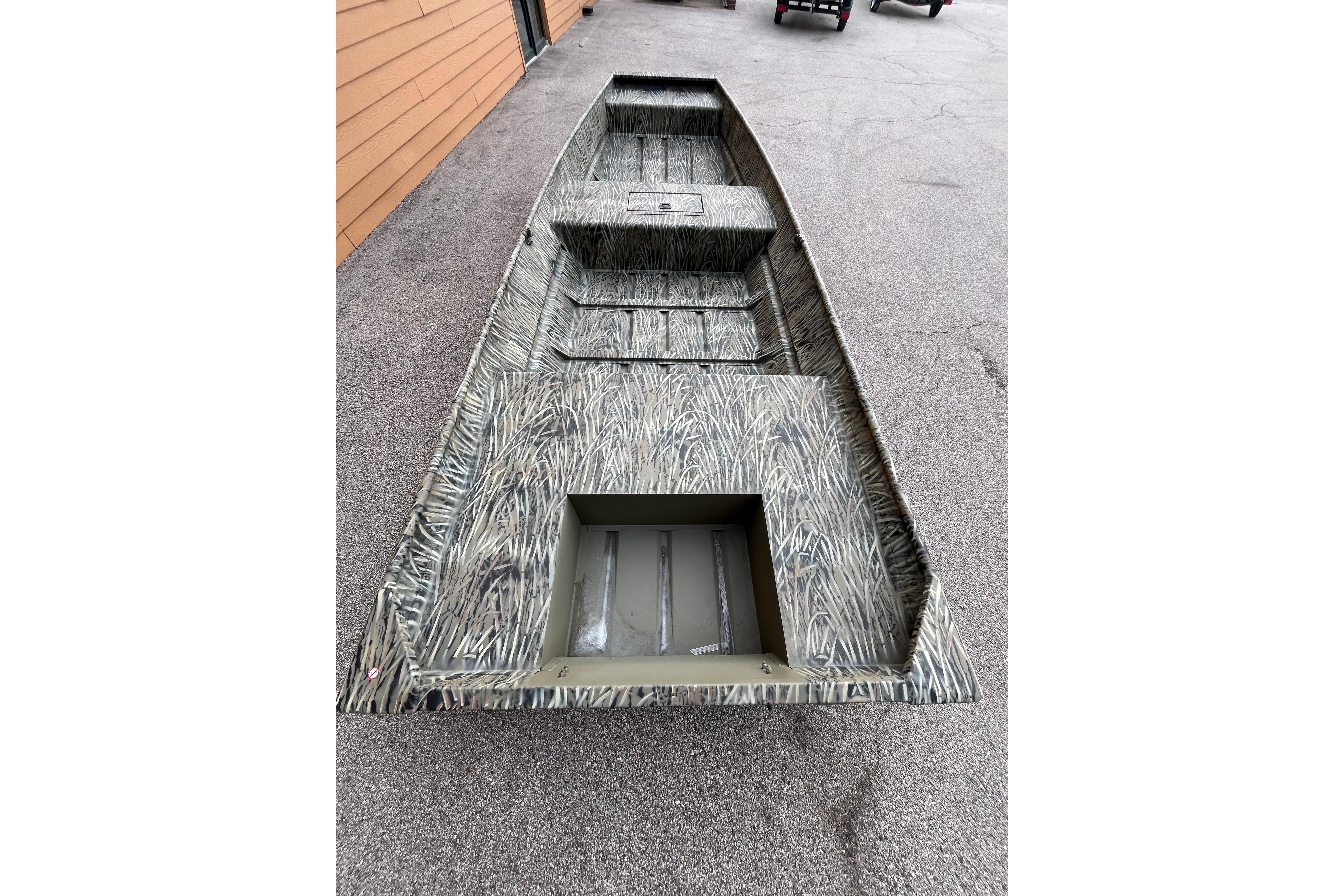 2026 Tracker Grizzly 15 Jon boat with camouflage design on pavement.