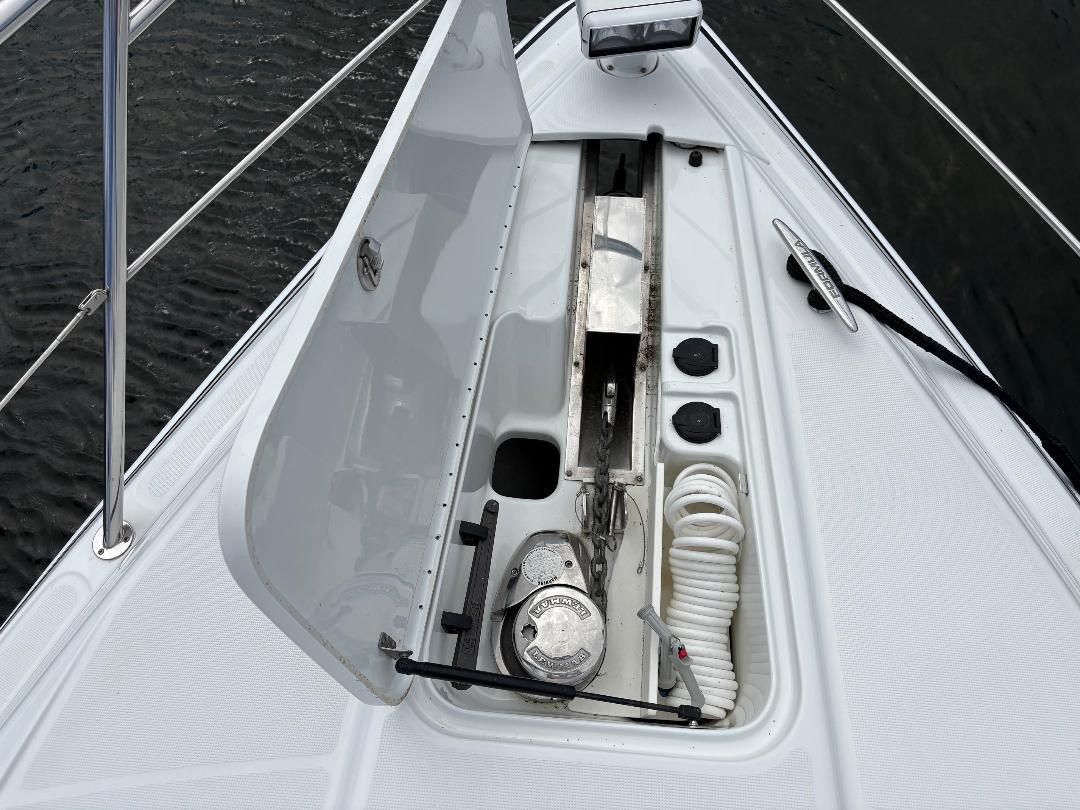 The image shows a boat's anchor area with a windlass and rope storage.