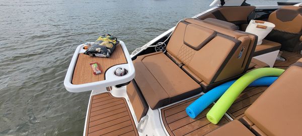 Yamaha Boats 2024 252SE with brown seating and table on the water.