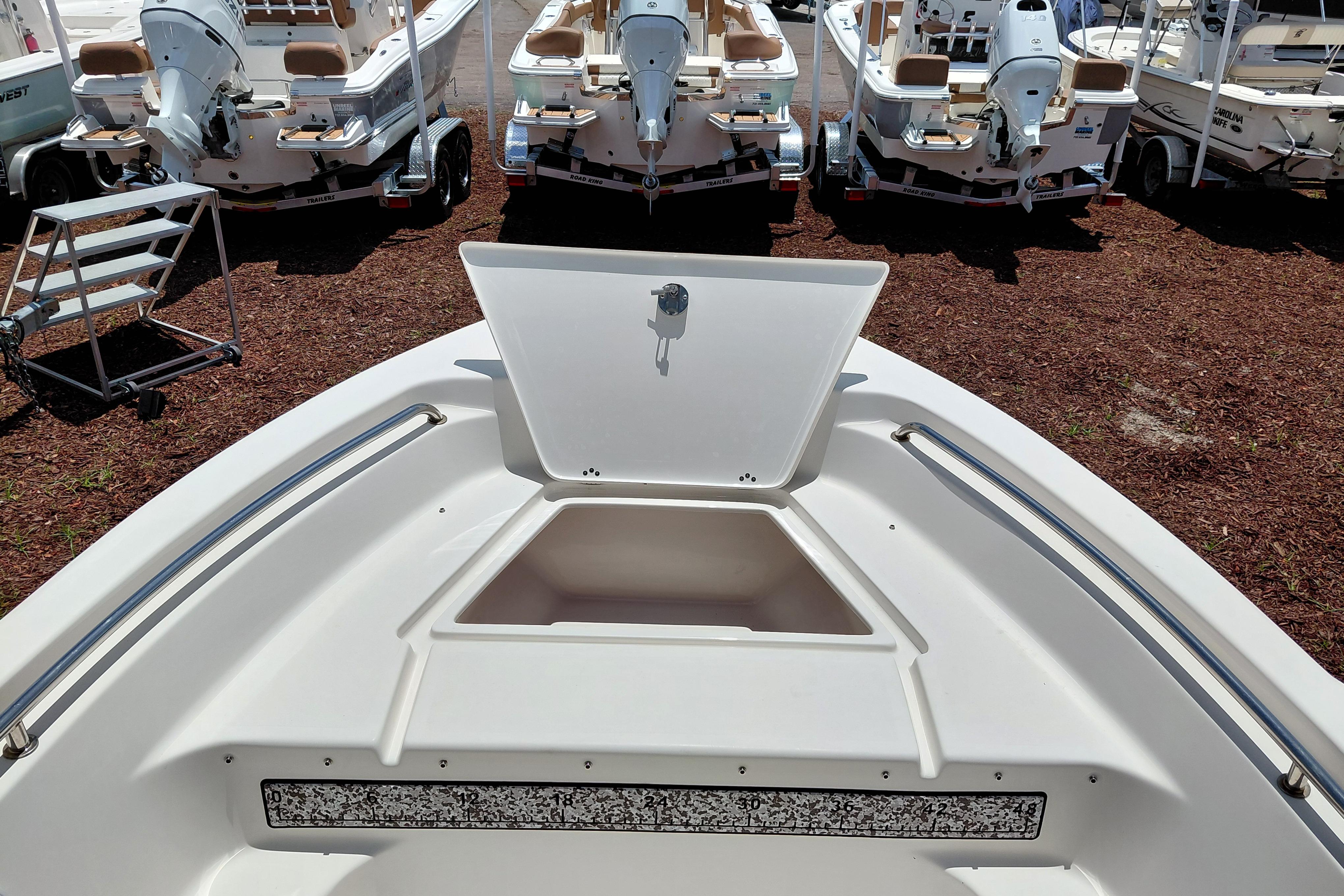 2023 Key West 189 FS boat with open storage compartment, surrounded by other boats.