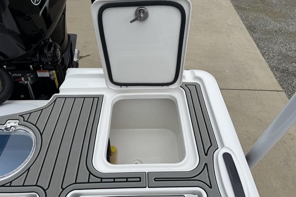 Open storage compartment on 2026 Tidewater 2500 Carolina Bay boat, featuring sleek design and secure latch.
