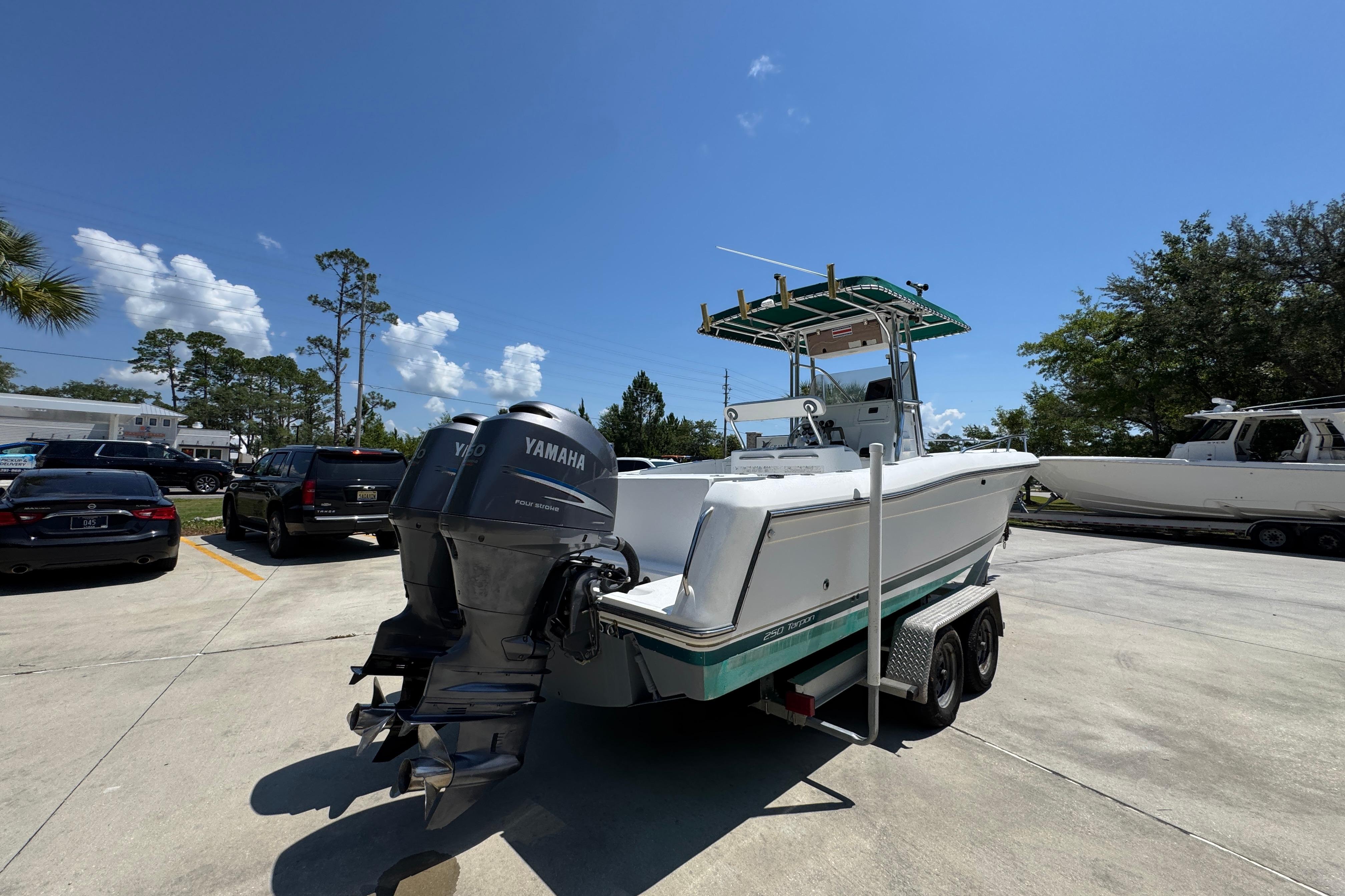 2000 Stamas 250 Tarpon boat with Yamaha outboard engines on a trailer in a parking lot.