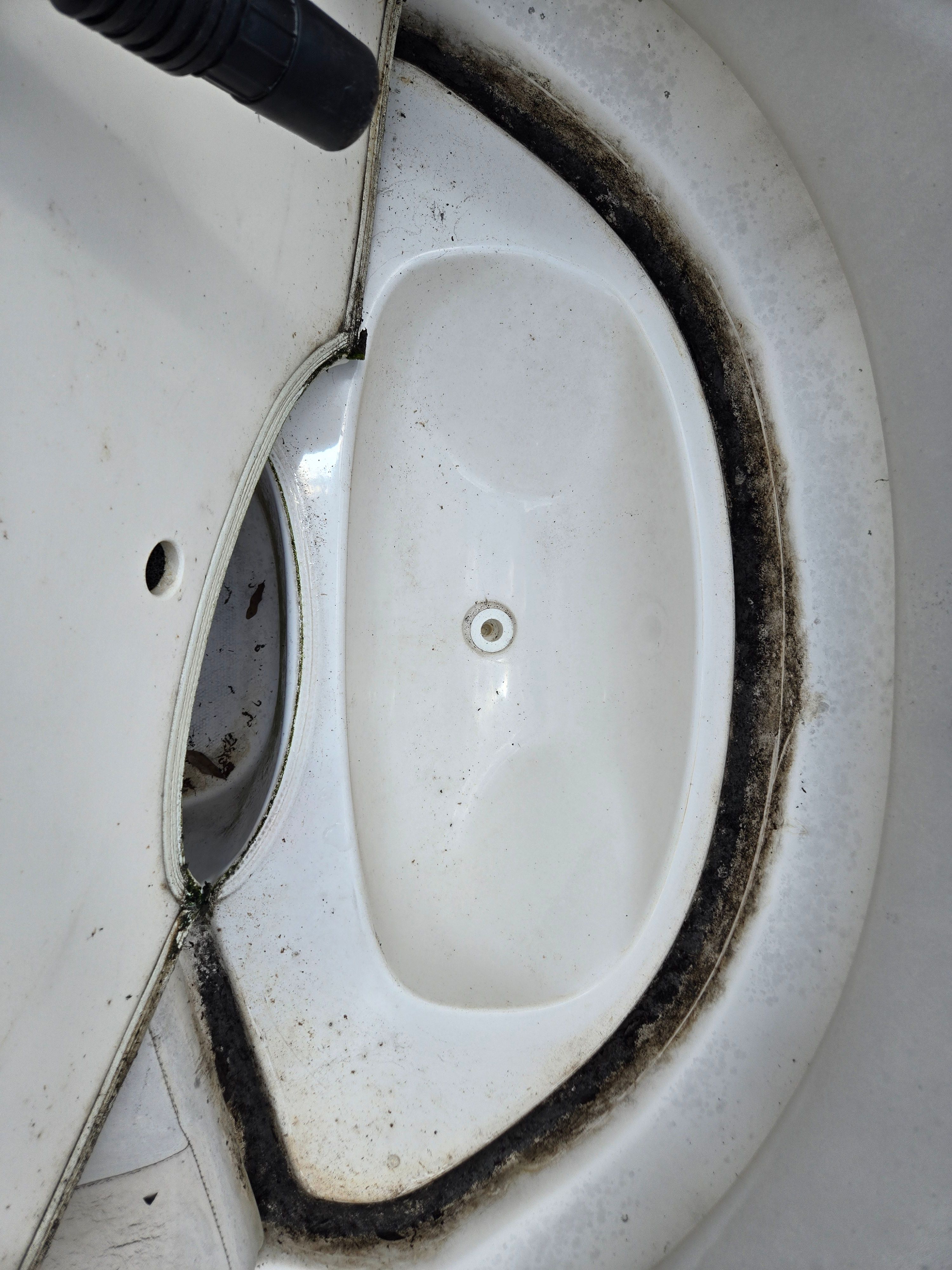 Close-up of a white boat part with dirt in the grooves.