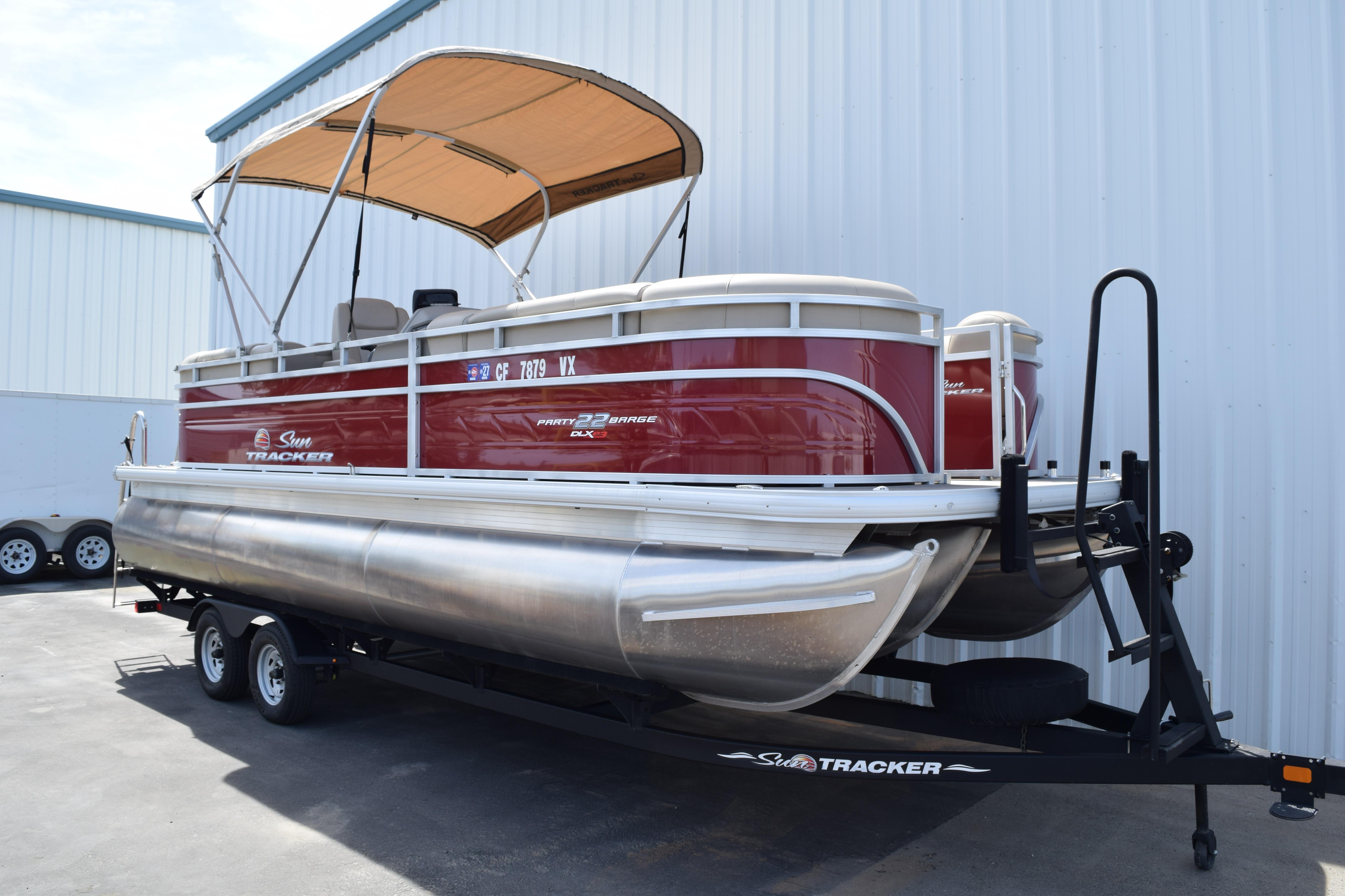 2025 Sun Tracker Party Barge 22 XP3 pontoon boat on trailer, parked outdoors.