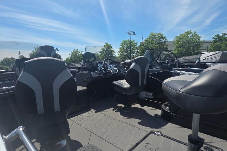 2026 Nitro ZV21 boat interior with modern seating and steering, under a clear blue sky.