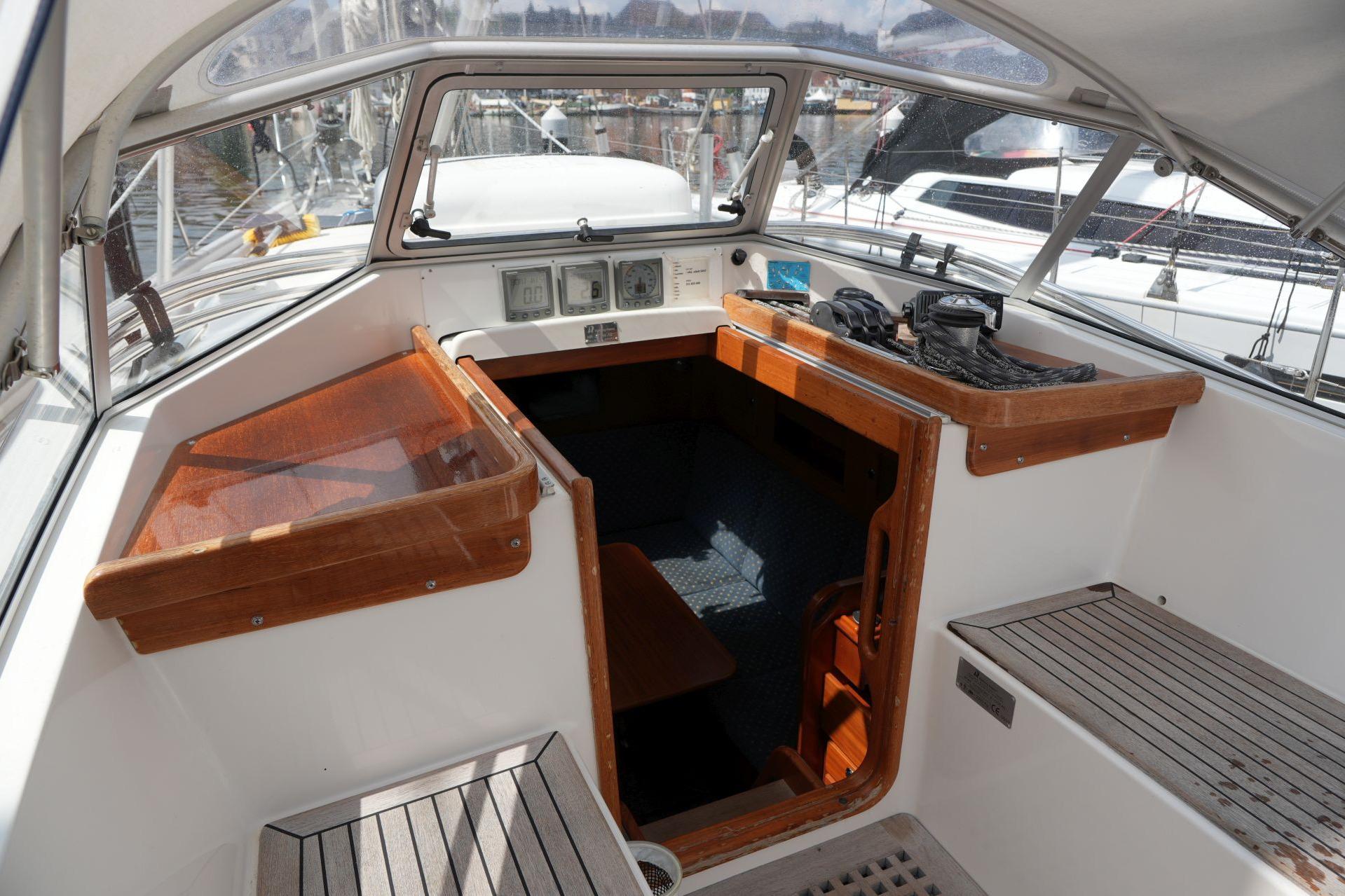 Interior view of a 2005 Hallberg-Rassy 37 sailboat cockpit with wooden accents.