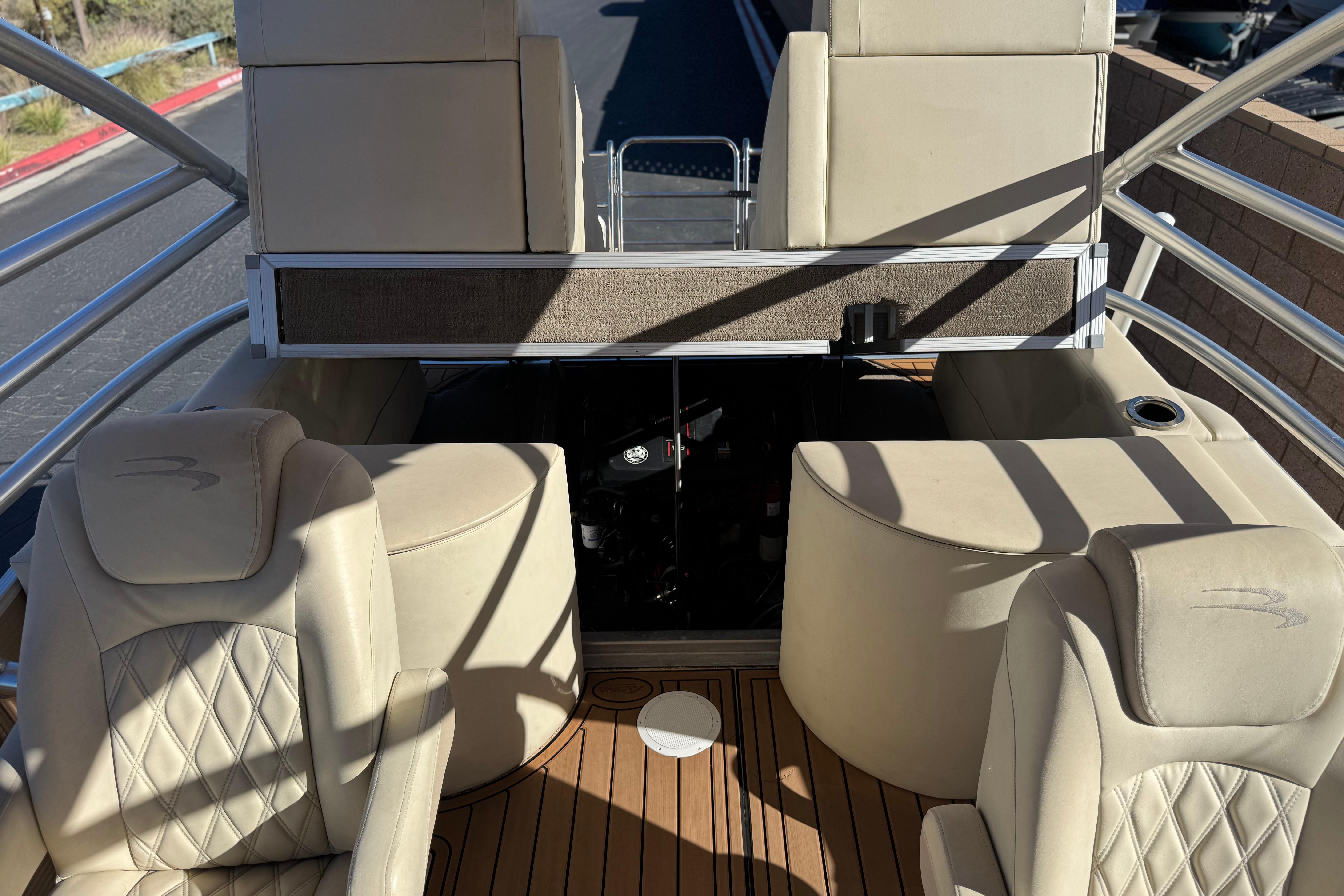 2013 Bennington 2575QCW I/O boat interior with beige seating and wood flooring.