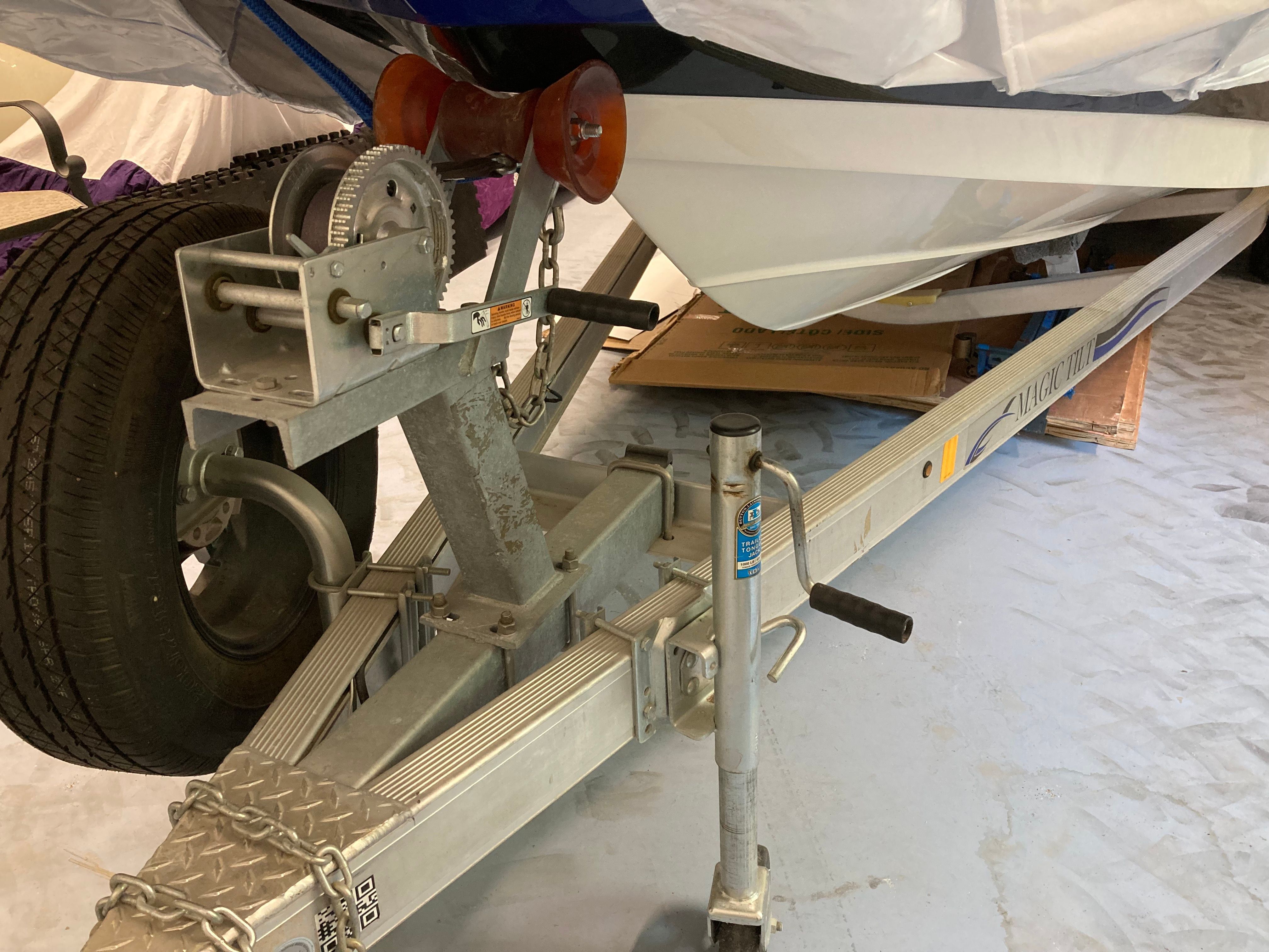 Boat on a trailer with a winch and support wheel.