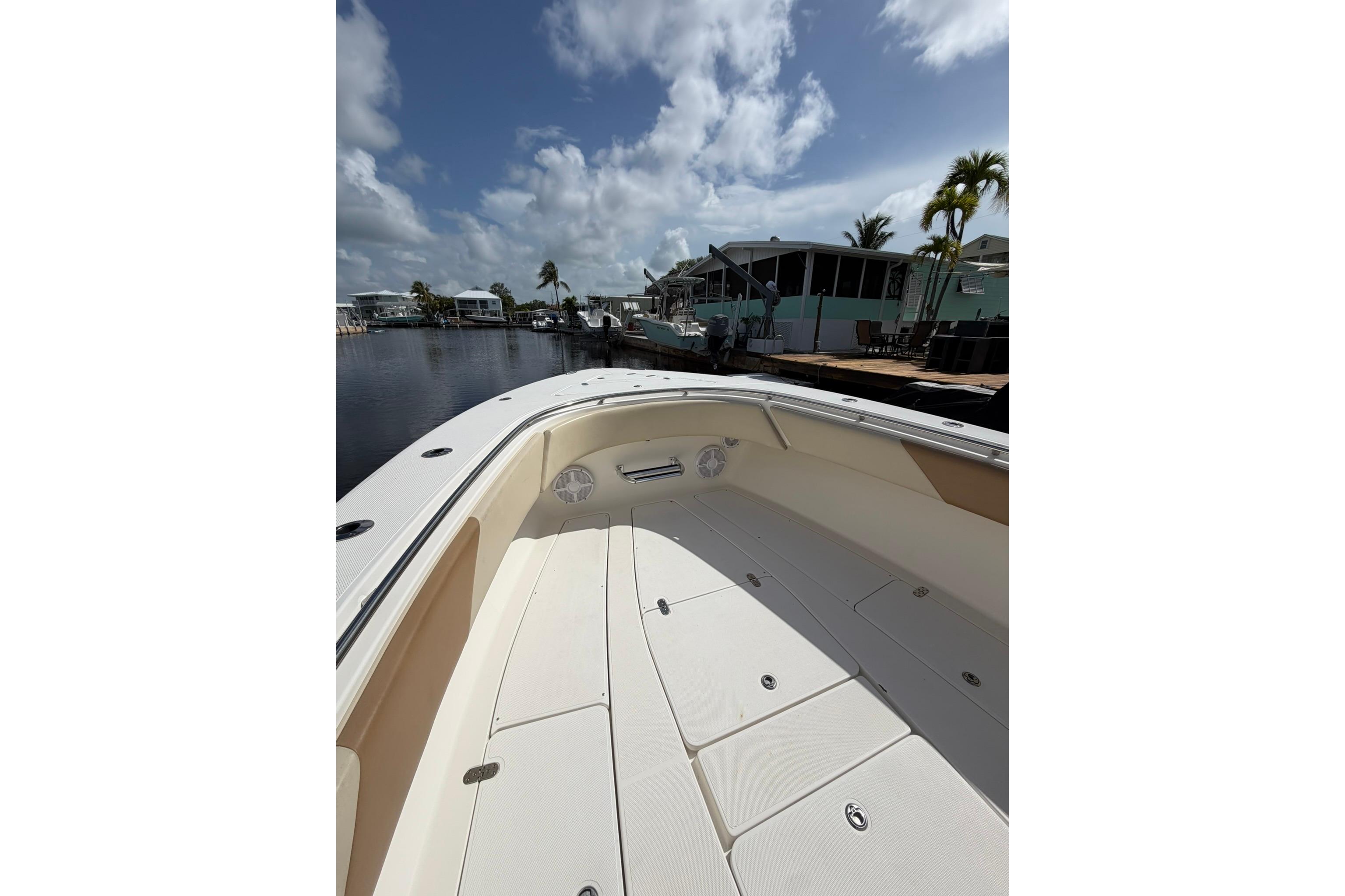 2007 Fountain 34 Center Console boat docked under a partly cloudy sky.
