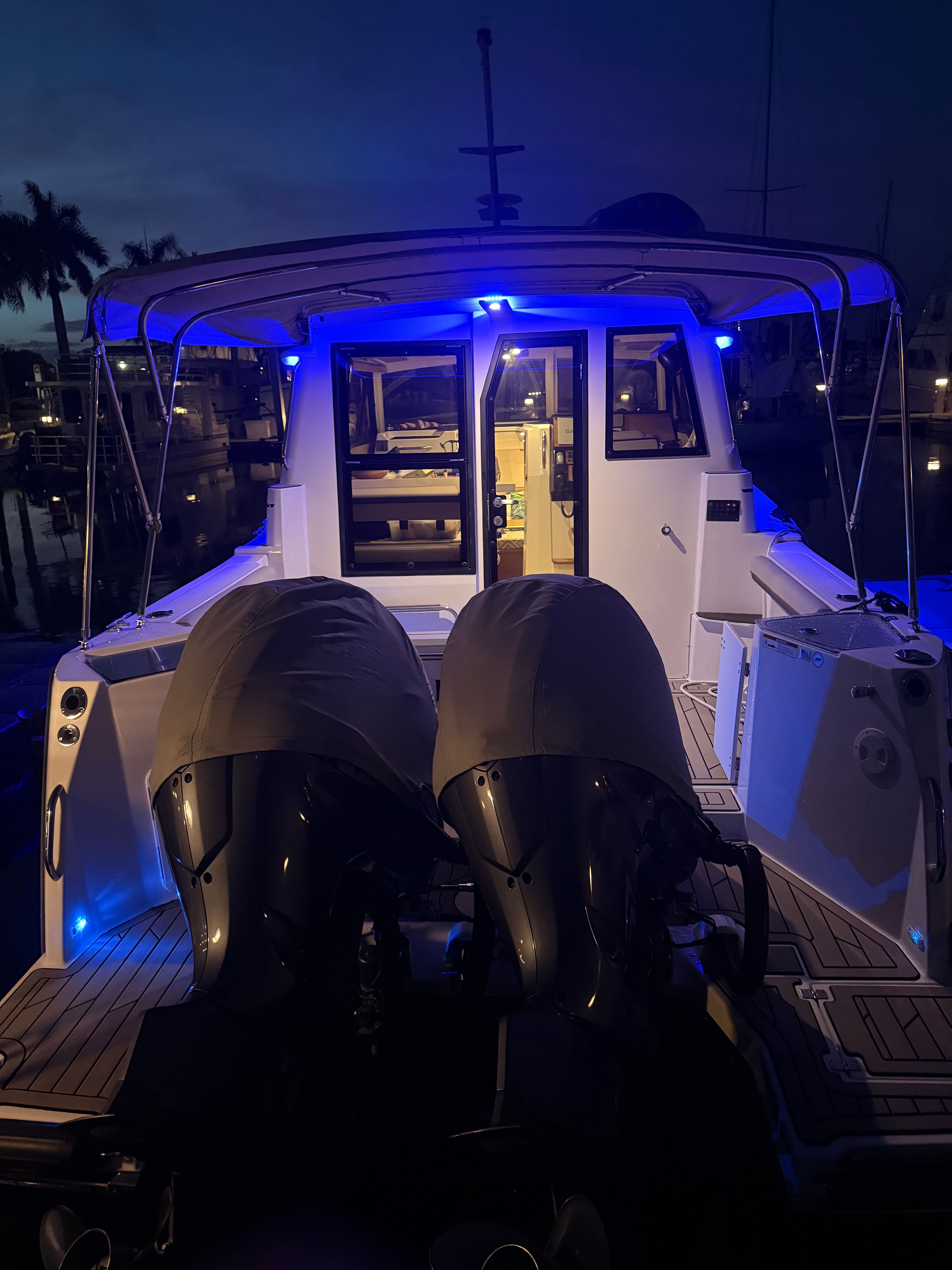 Cutwater C-228 2023: Illuminated cockpit with twin engines, docked at night.