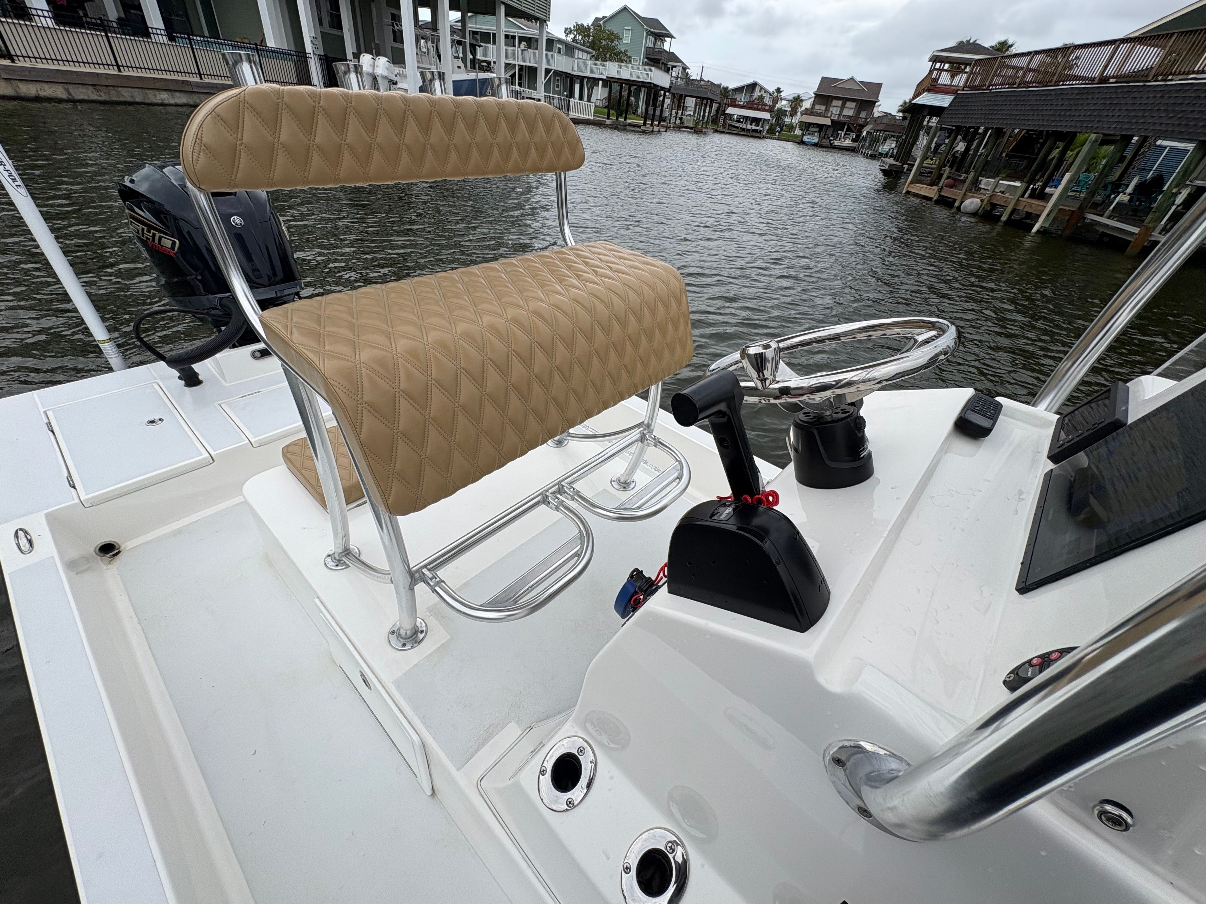 The image shows the cockpit of a 2025 Shallow Sport 24 Sport boat with a cushioned seat.