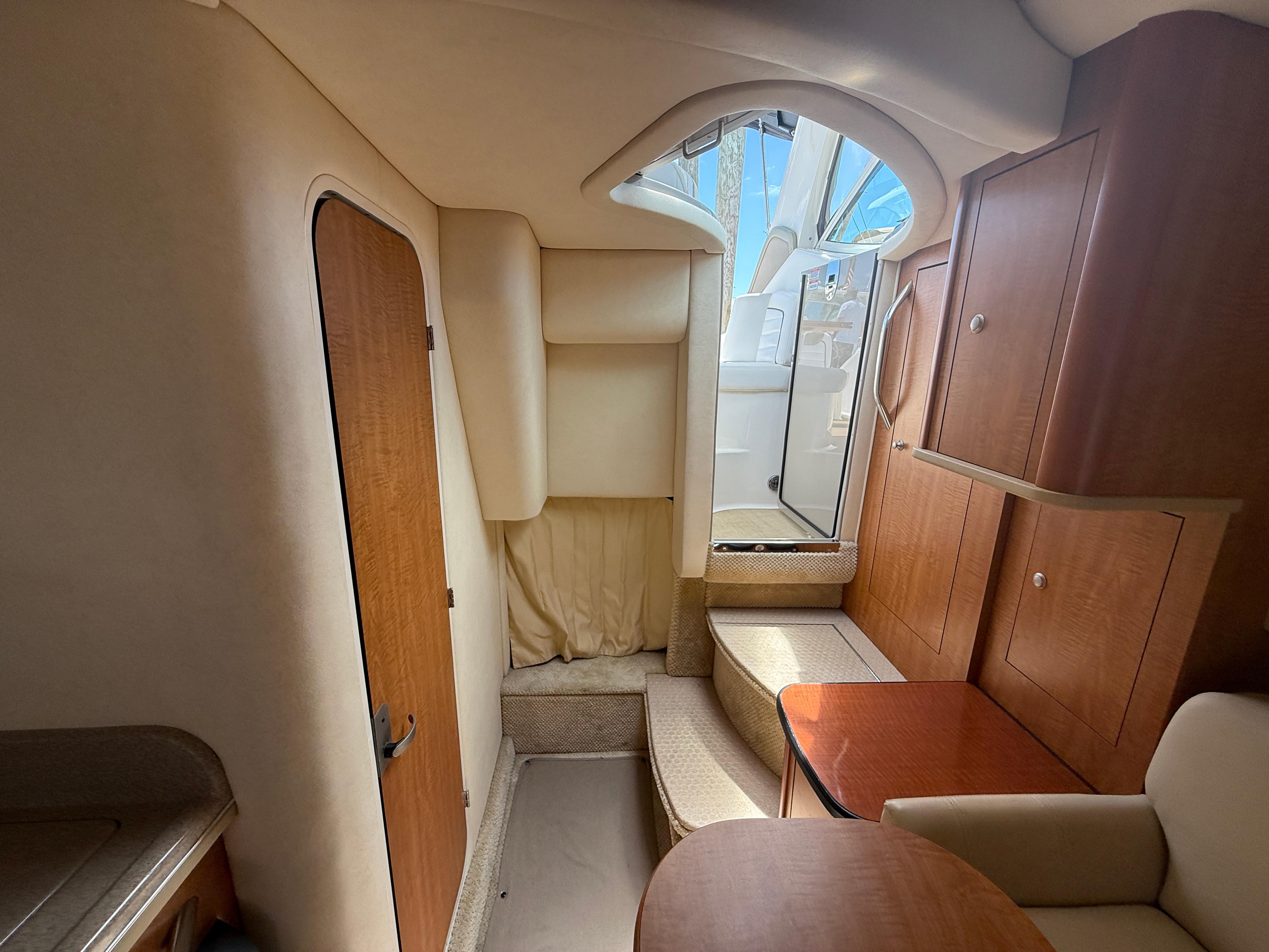 Interior of 2006 Sea Ray 290 Sundancer boat, featuring wood cabinetry and seating area.