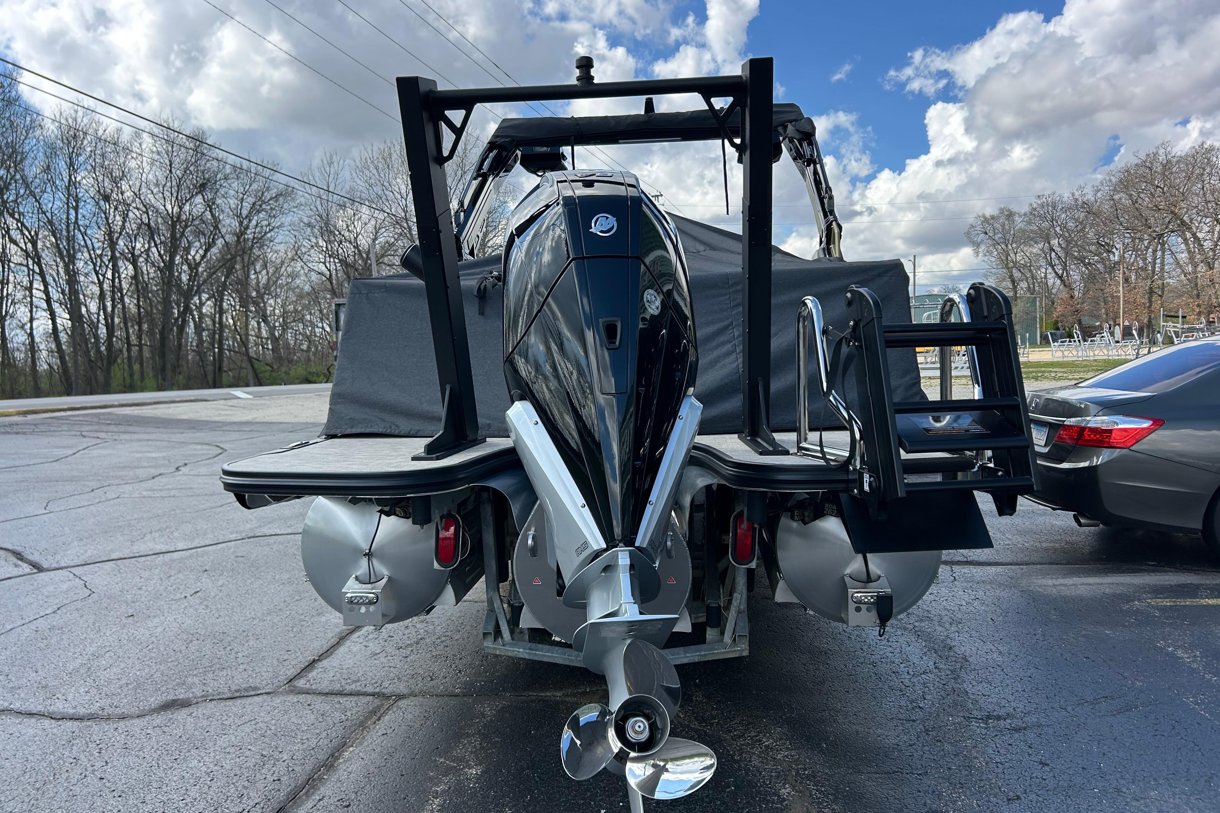 Alera M23L 2026 boat with powerful outboard motor, parked on a paved surface.