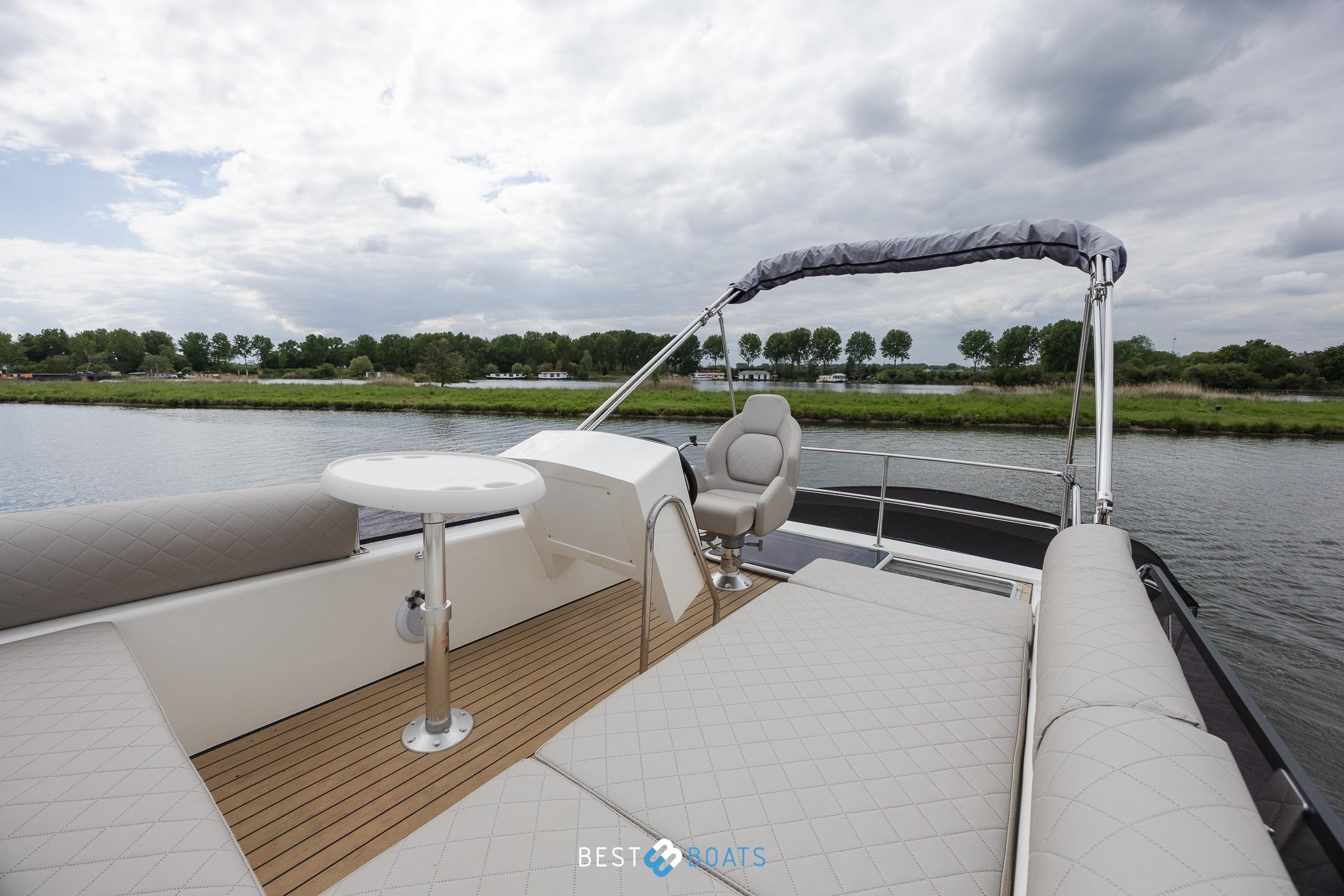 2023 Cobra Yachts Futura 36 Premium Fly, luxurious deck view on a serene waterway.