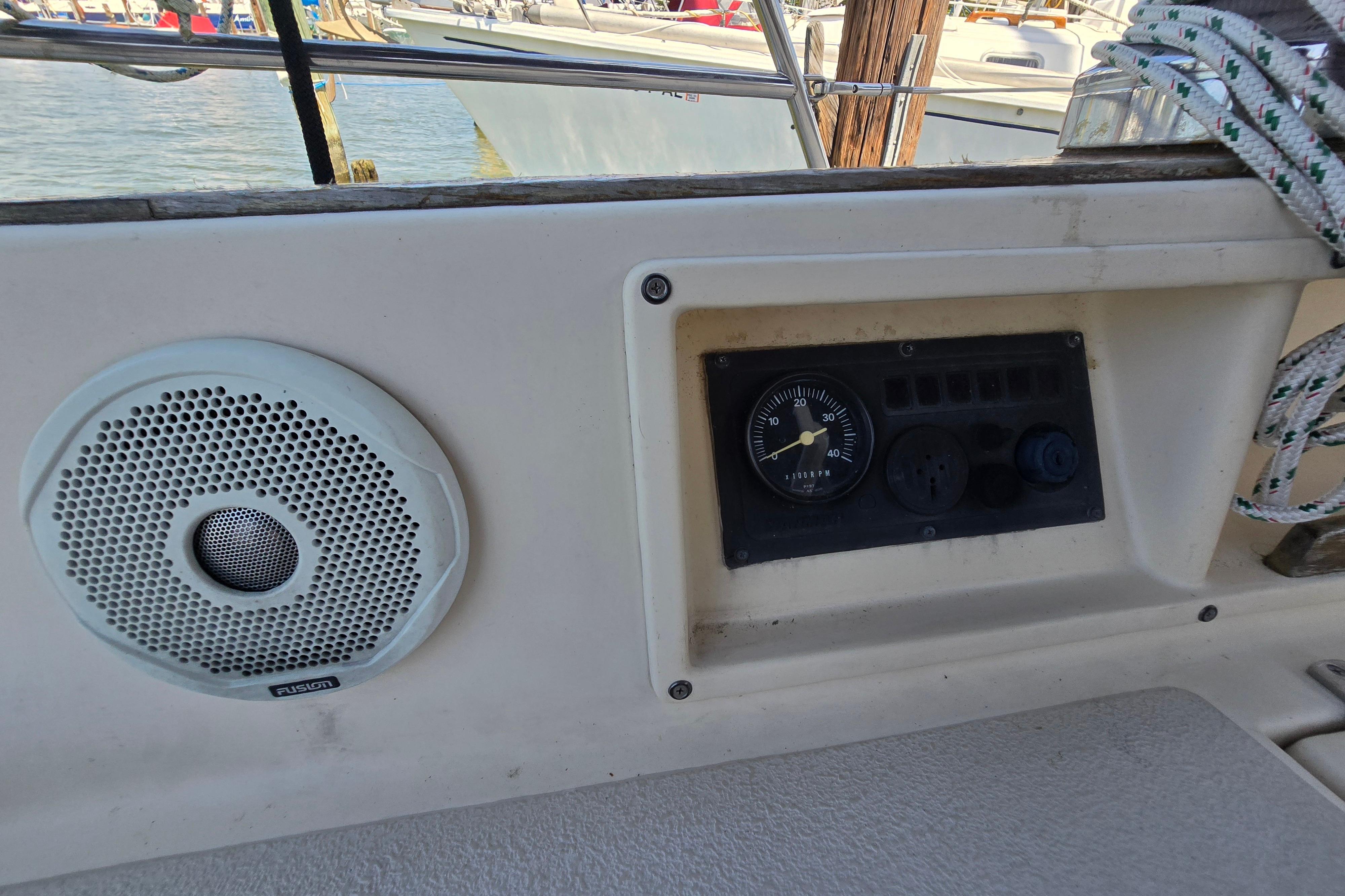 Control panel and speaker on a 1993 Caliber 35 sailboat, docked at a marina.