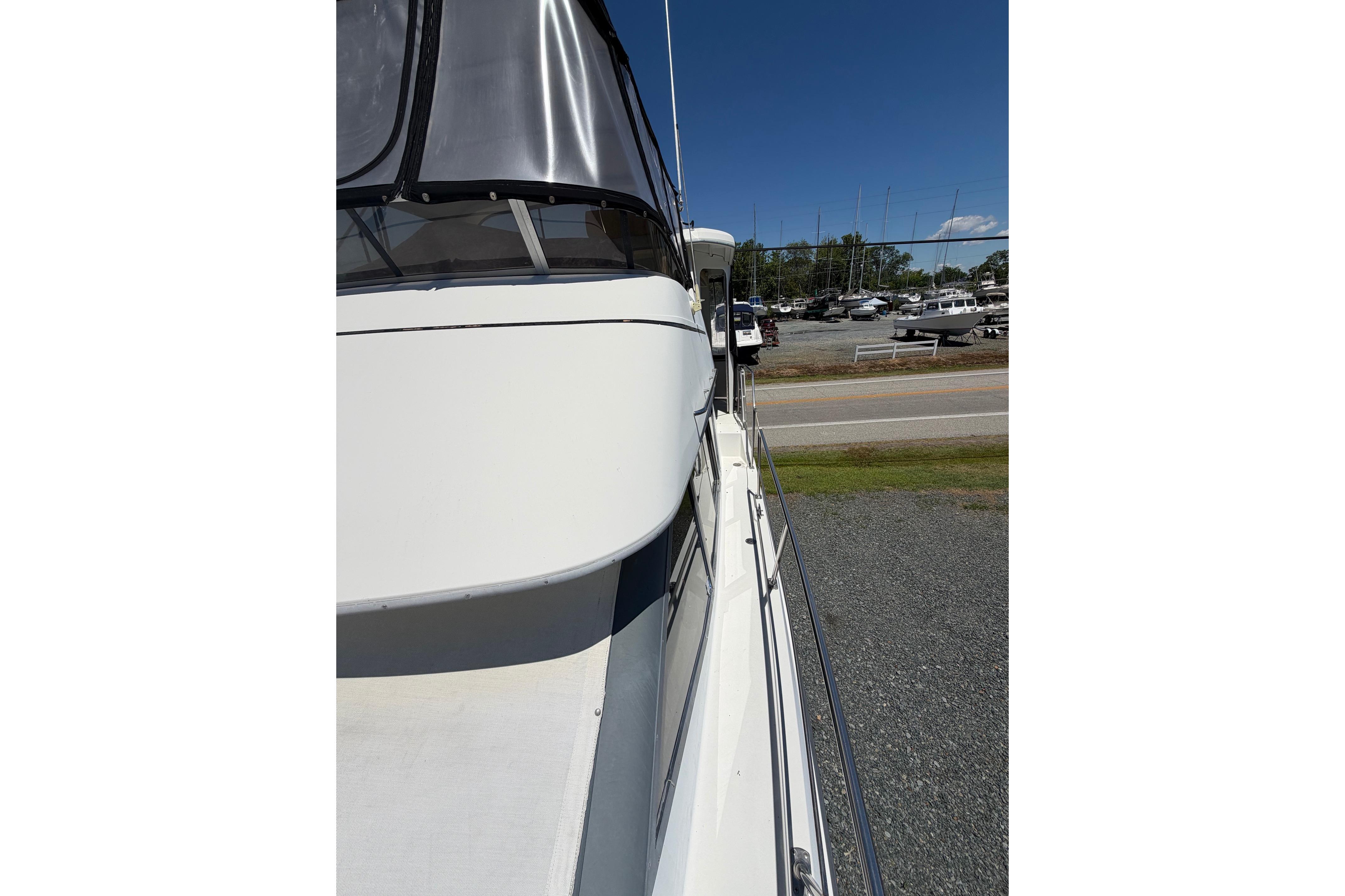 1995 Carver 356 Aft Cabin Motor Yacht docked, side view under clear blue sky.