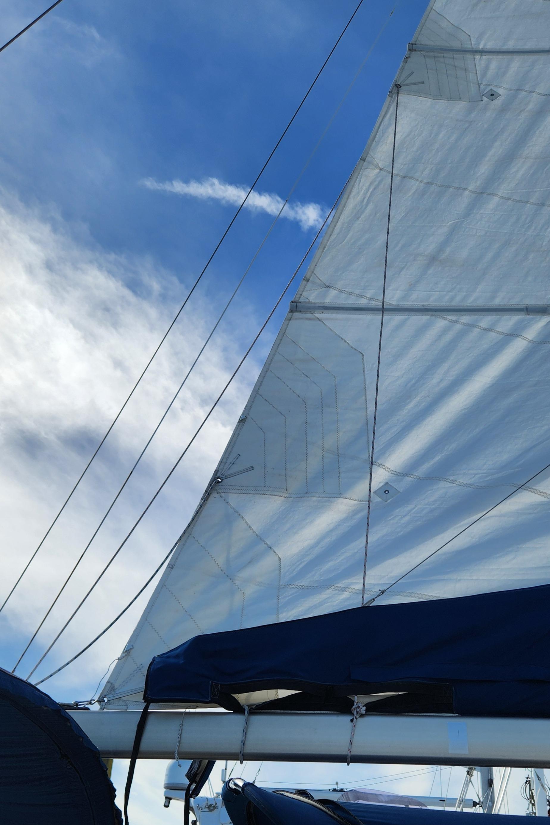 Sailboat with white sails against a blue sky, Catalina 400, 1998 model.