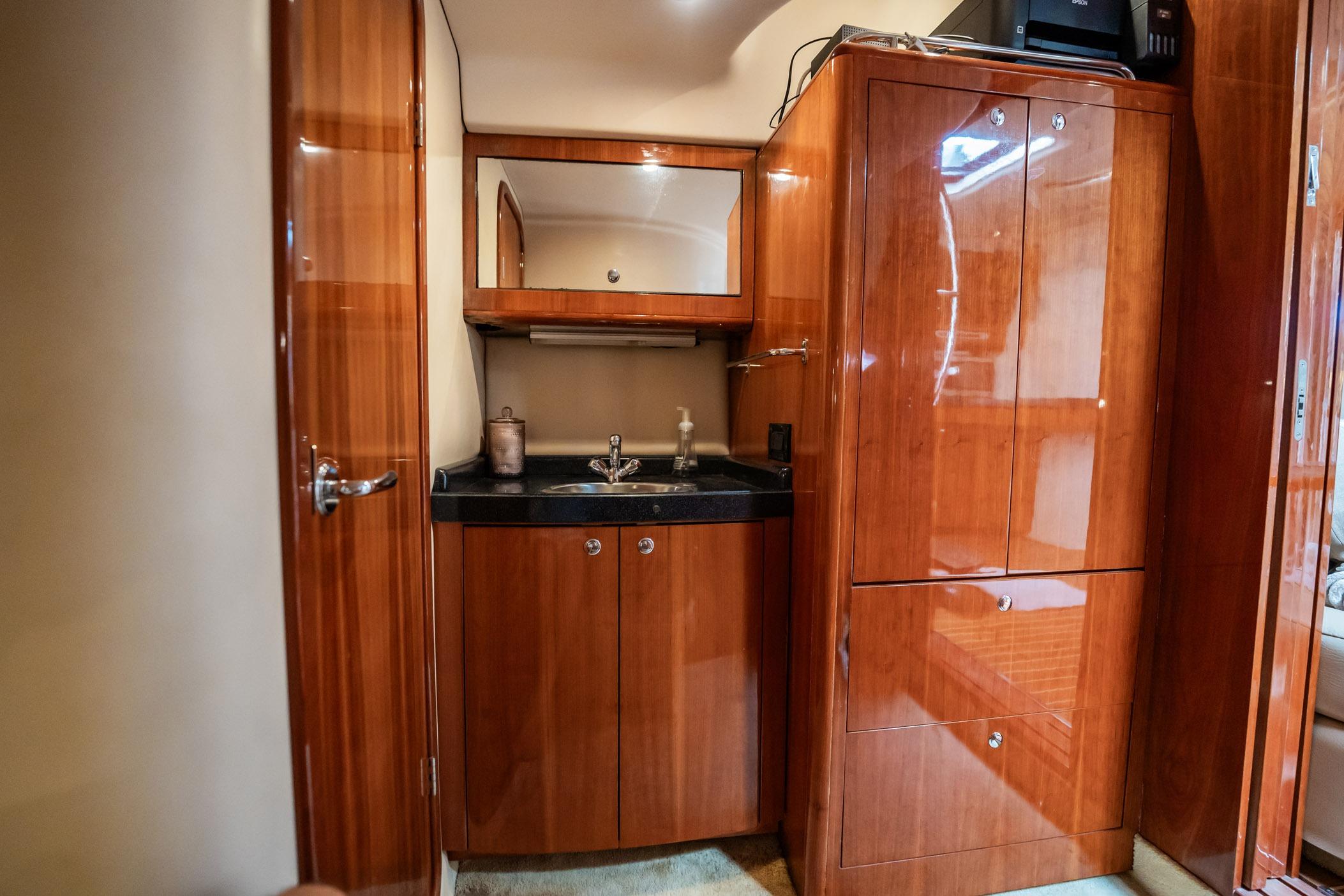 Luxurious wood-finished interior of 2008 Regal Commodore 4460 yacht with sink and cabinets.