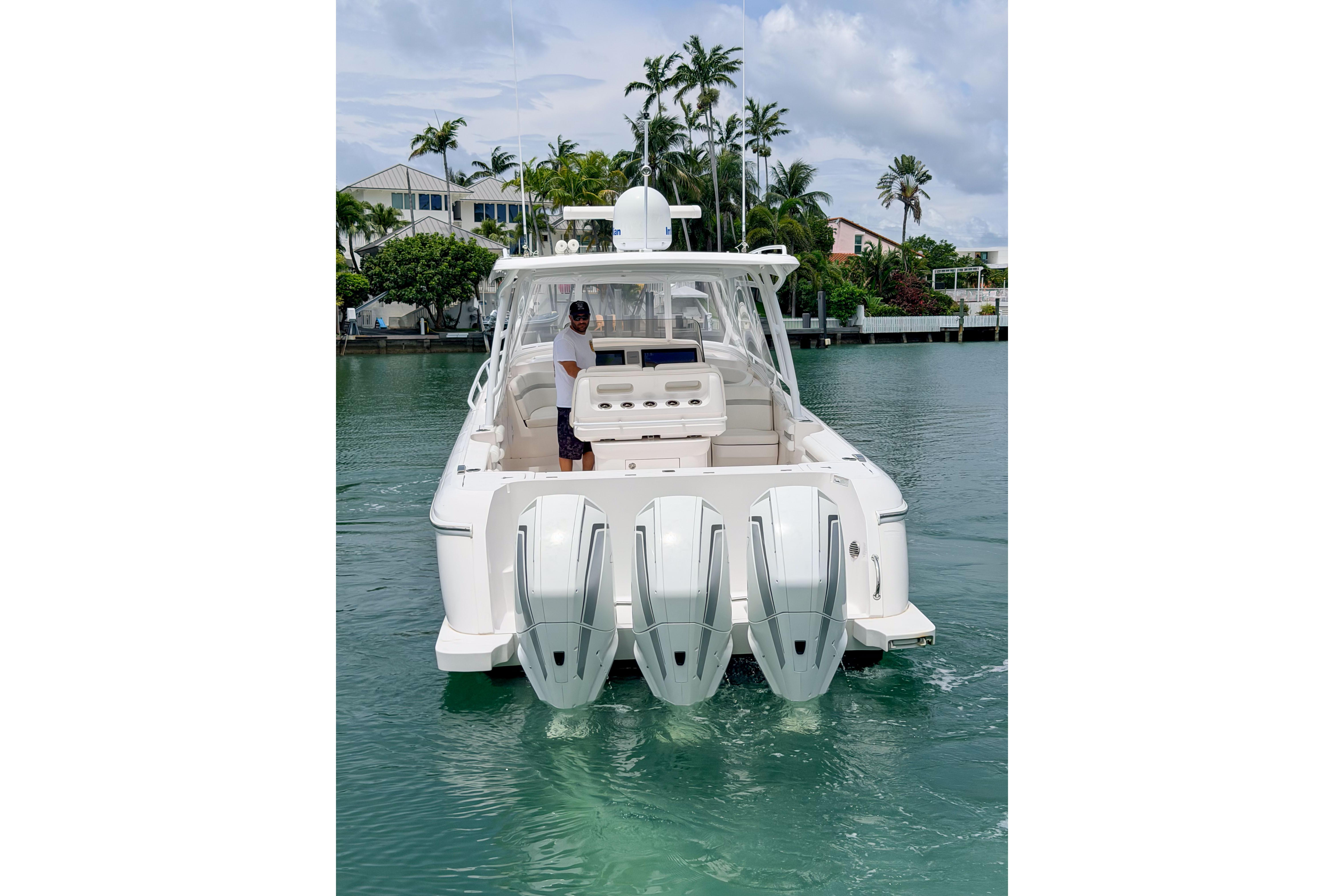 2021 Intrepid 409 Valor boat with triple outboard engines on a calm waterway.