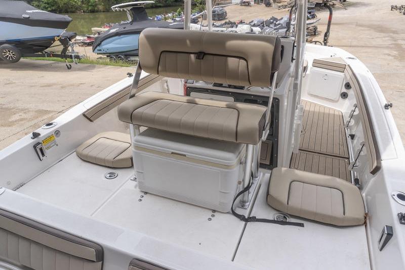 2023 Yamaha Boats 195 FSH Sport interior with seating and storage, docked near other boats.