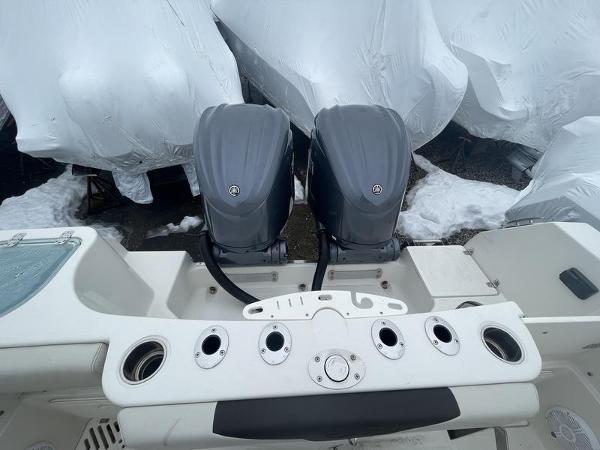 2023 Sailfish 290 CC boat with dual outboard motors, covered boats in background.