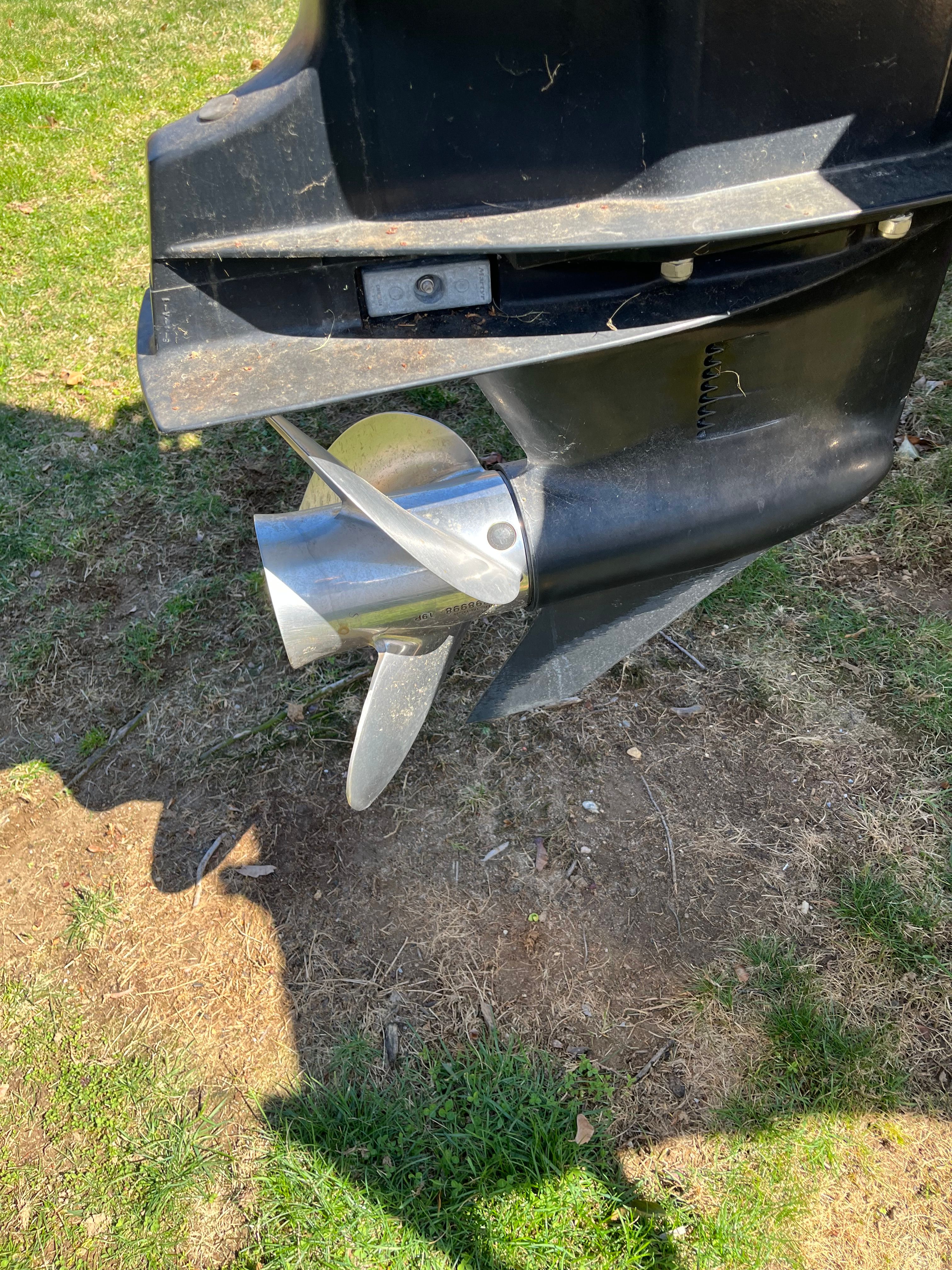 Close-up of a boat propeller on a grassy area.