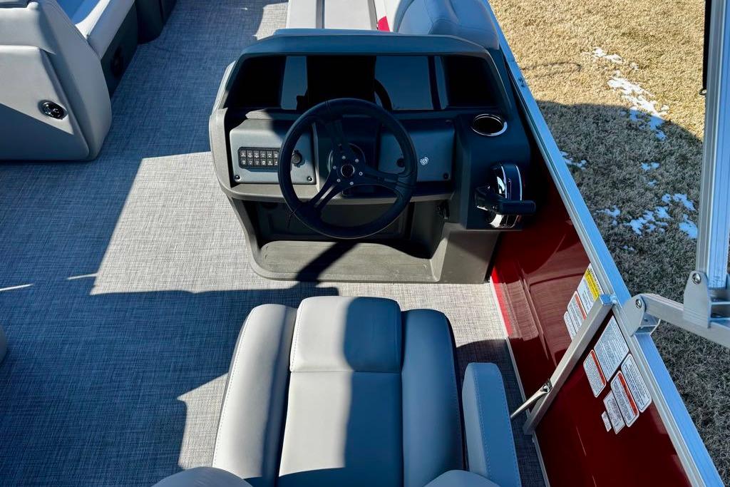 2026 Sun Tracker Party Barge 20 DLX boat interior with steering console and seating.