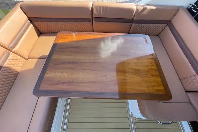 Luxurious seating area on a 2016 Sea Ray Sundancer 510 yacht with a polished wooden table.