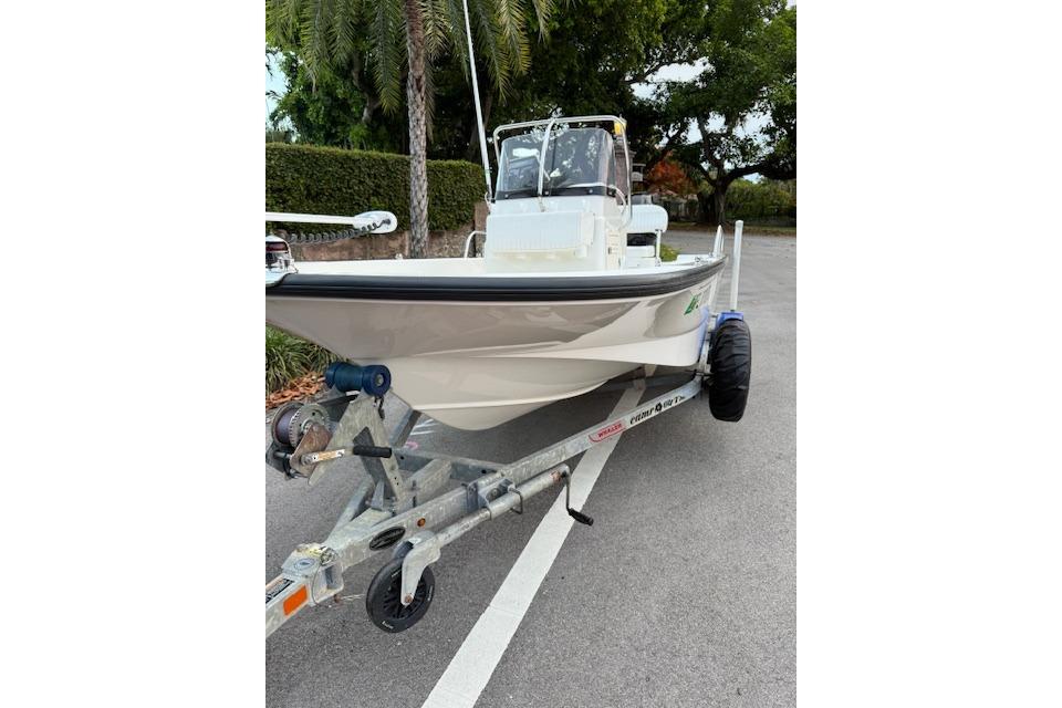 2016 Boston Whaler 150 Montauk boat on trailer, parked on a road.