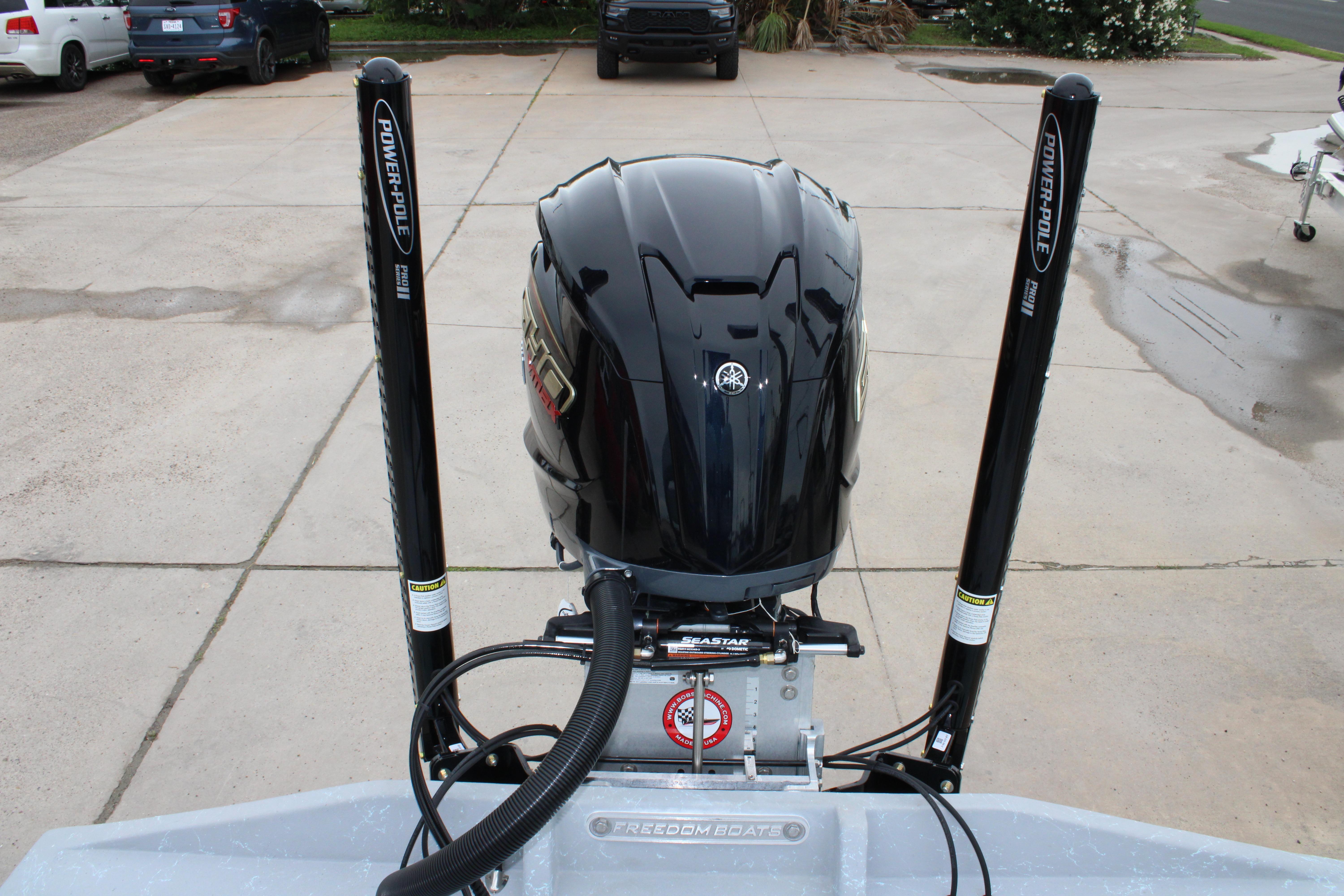 2026 Freedom Boats 24 Defender with Yamaha engine and Power-Pole anchors in a driveway.