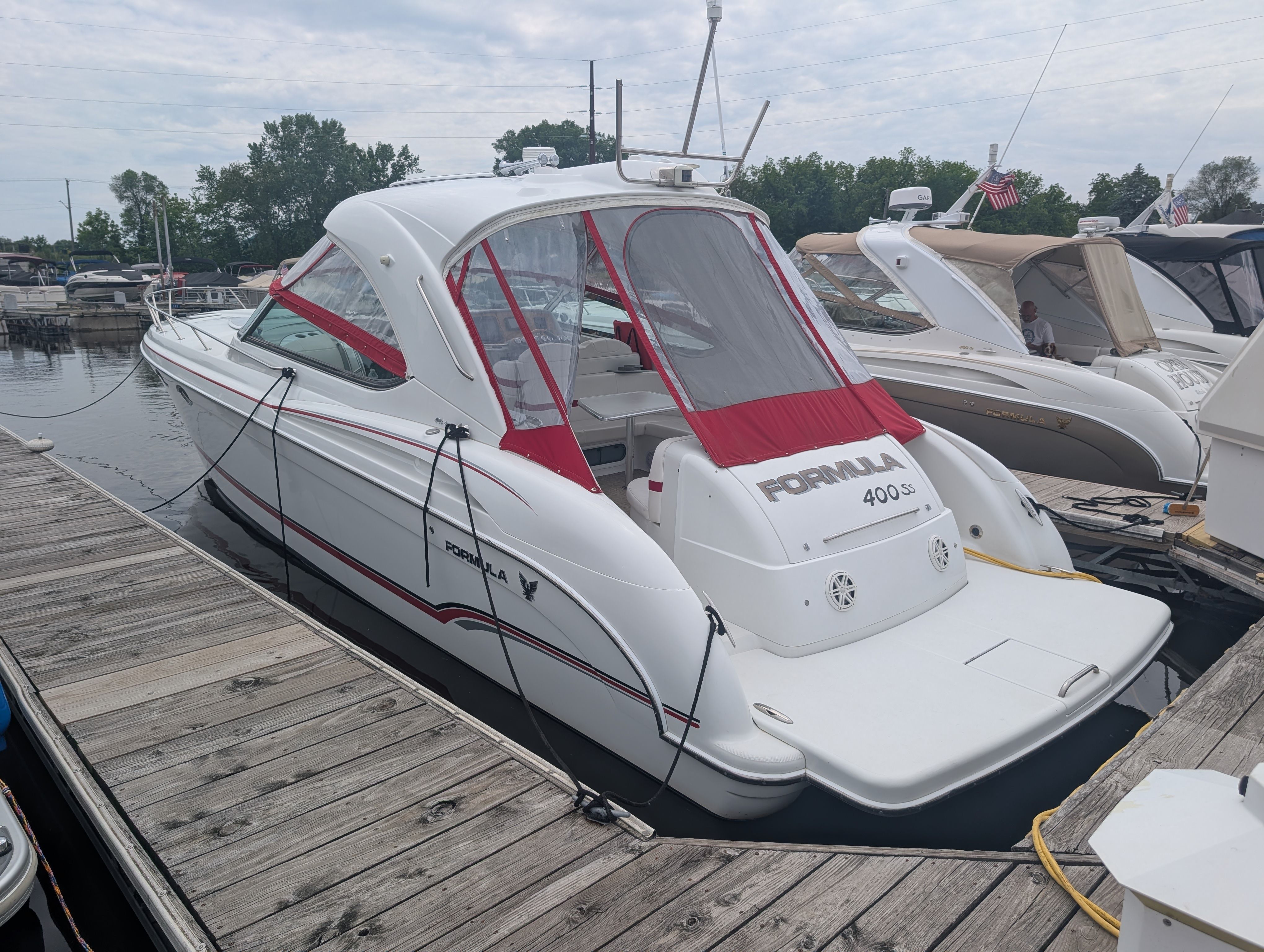 A white 2007 Formula 400 Super Sport docked at a wooden pier. It features red accents.