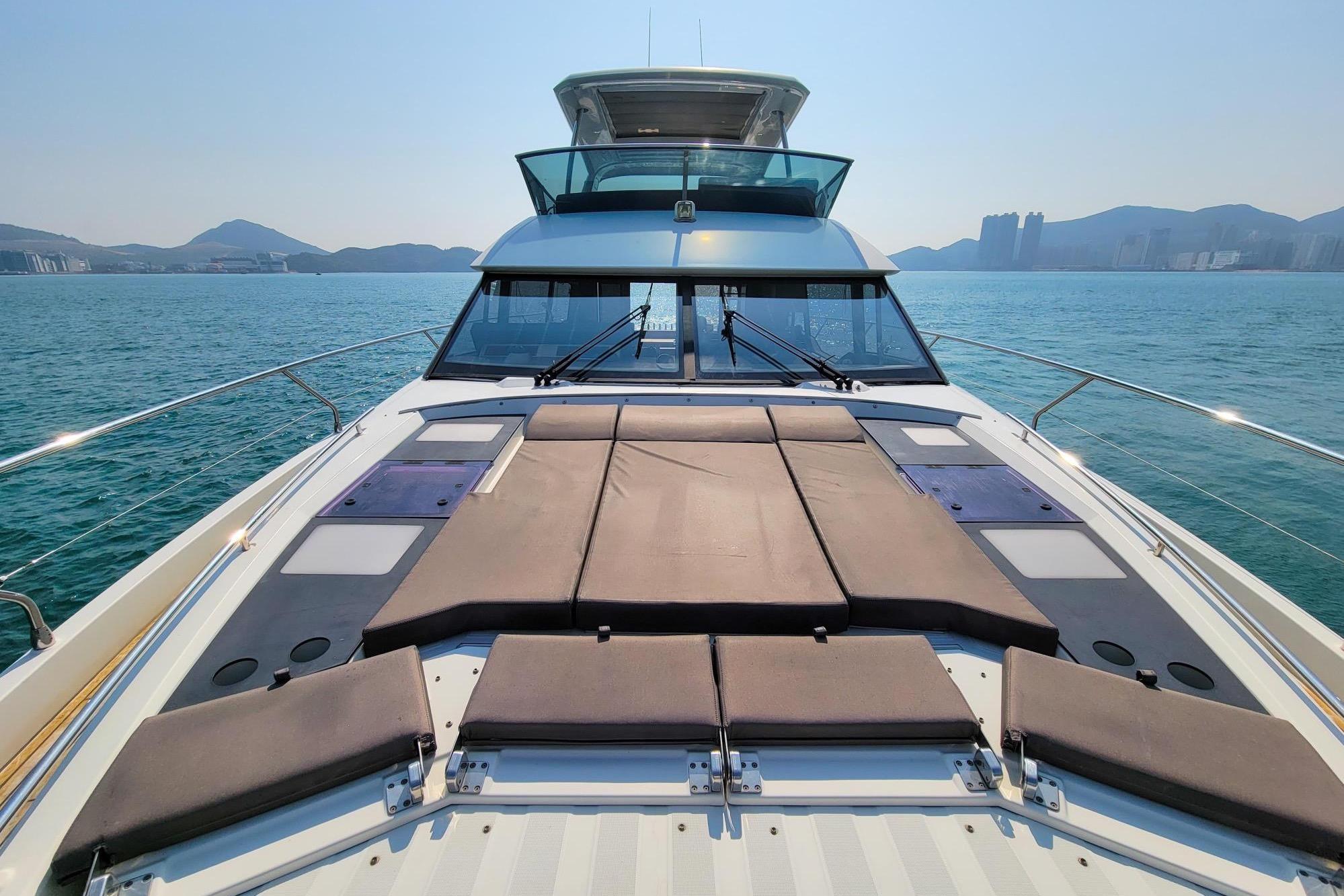 Luxury 2019 Prestiage 630 yacht on serene ocean with scenic mountain backdrop.